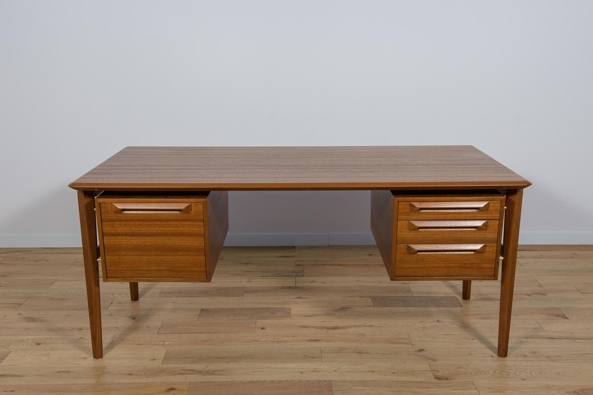 Der Schreibtisch wurde von dem dänischen Designer Ib Kofod-Larsen entworfen und in den 1950er Jahren in der schwedischen Fabrik Seffle Möbelfabrik hergestellt. Der Schreibtisch mit einer interessanten modernistischen Form ist ein Beispiel für die