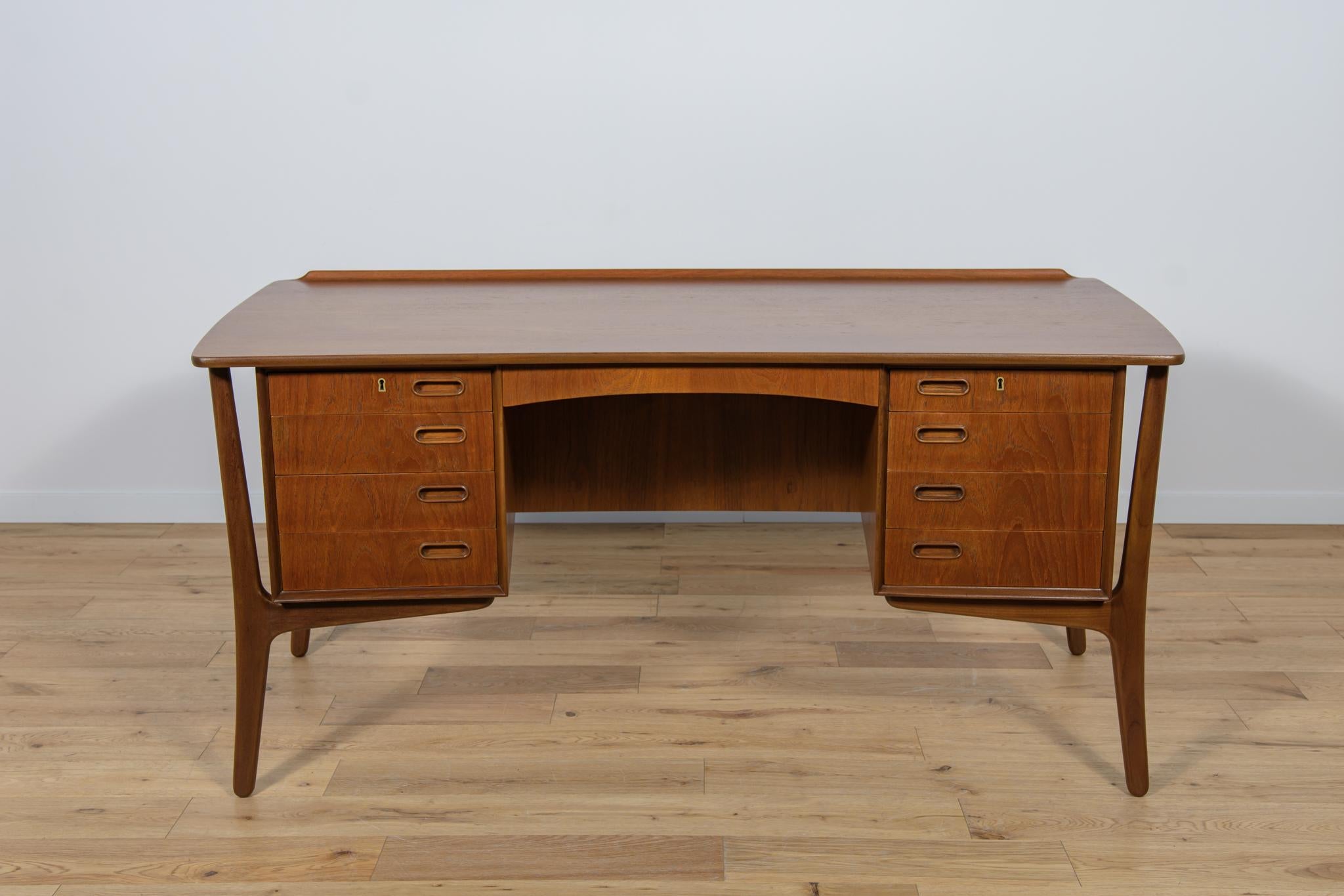 This desk is designed by Svend Åge Madsen and manufactured by h.p. Hansen in Denmark in the 1960s. It is a good example of high quality materials and manufacturing. This is a teak desk with eight drawers and an open shelf with a lockable cabinet at