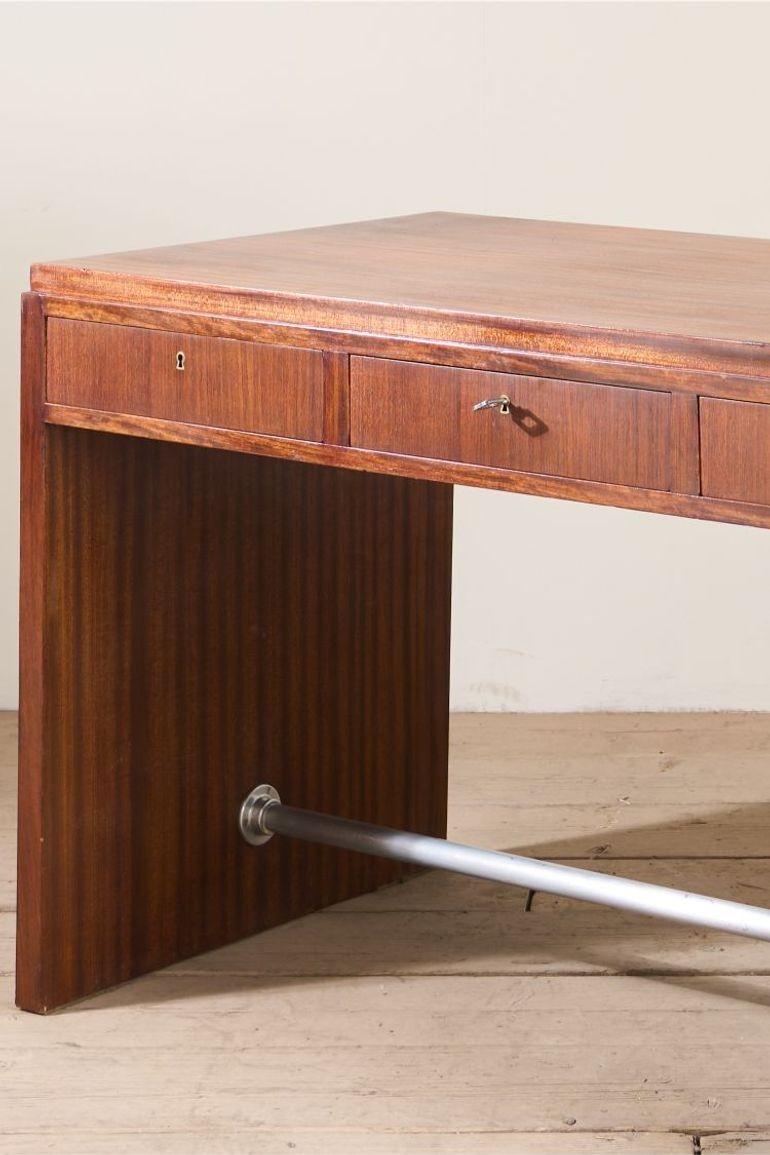 Si tratta di una scrivania in teak della metà del XX secolo dal design pulito. Il colore è favoloso e la semplicità del design è estremamente attraente. Le dimensioni sono molto pratiche per uno o più schermi con una buona profondità della