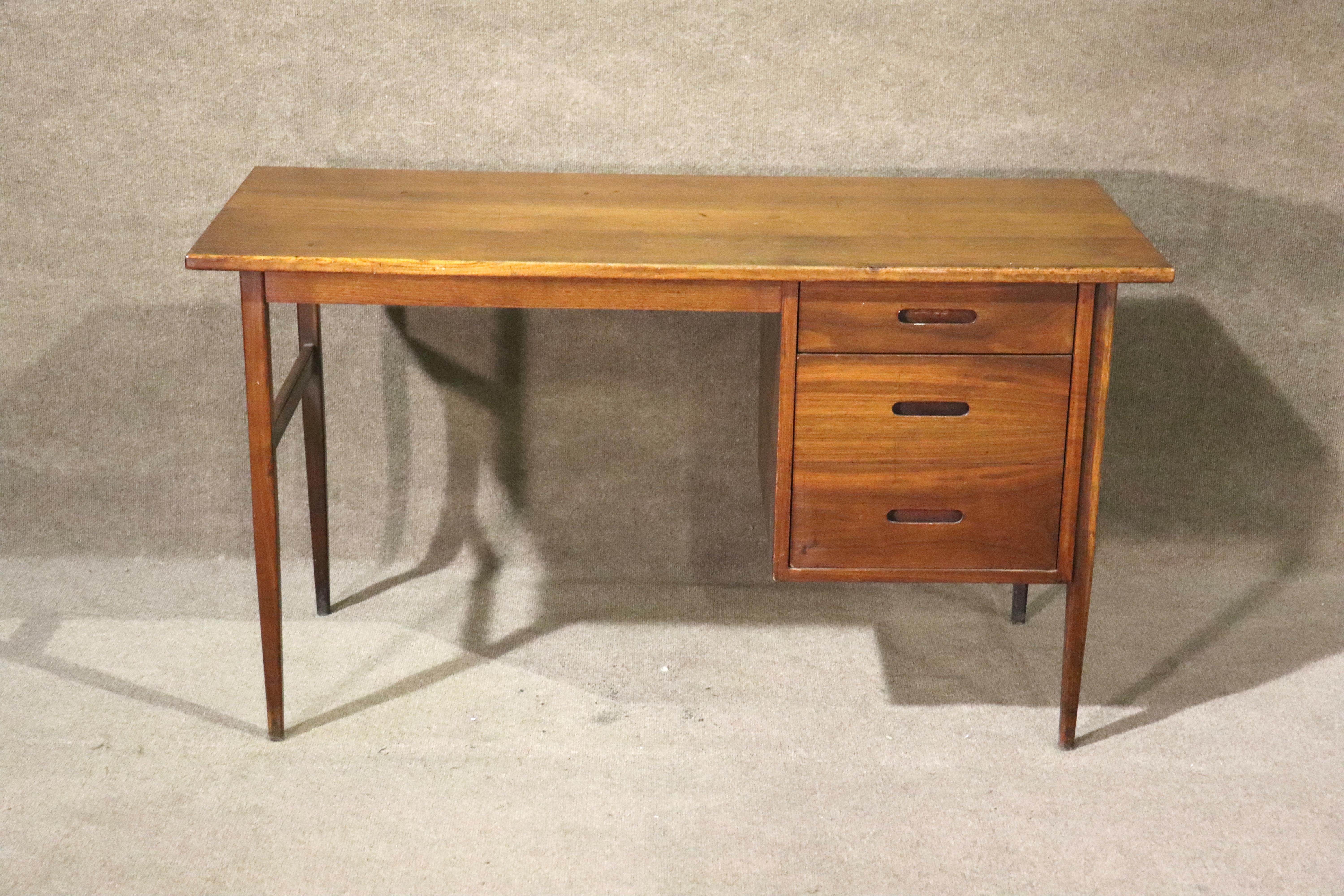 Mid-century modern writing desk in teak wood. Simple design with a two drawer bank and tapered legs.
Please confirm location NY or NJ