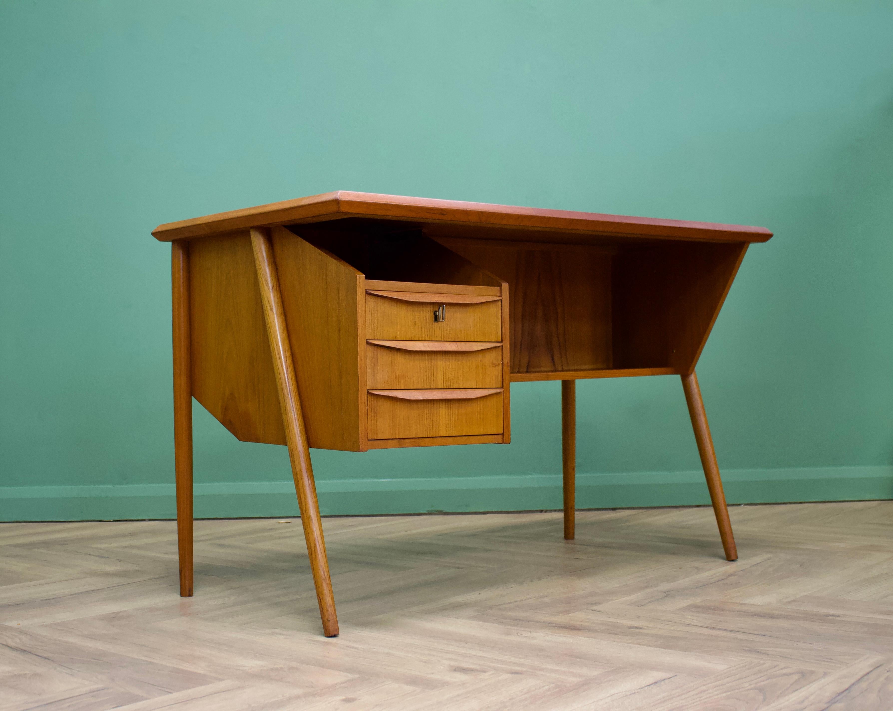 A compact Danish teak desk from Tibergaard.
Featuring a floating top design -3 drawers, shelves to the front and a bookshelf to the back.
