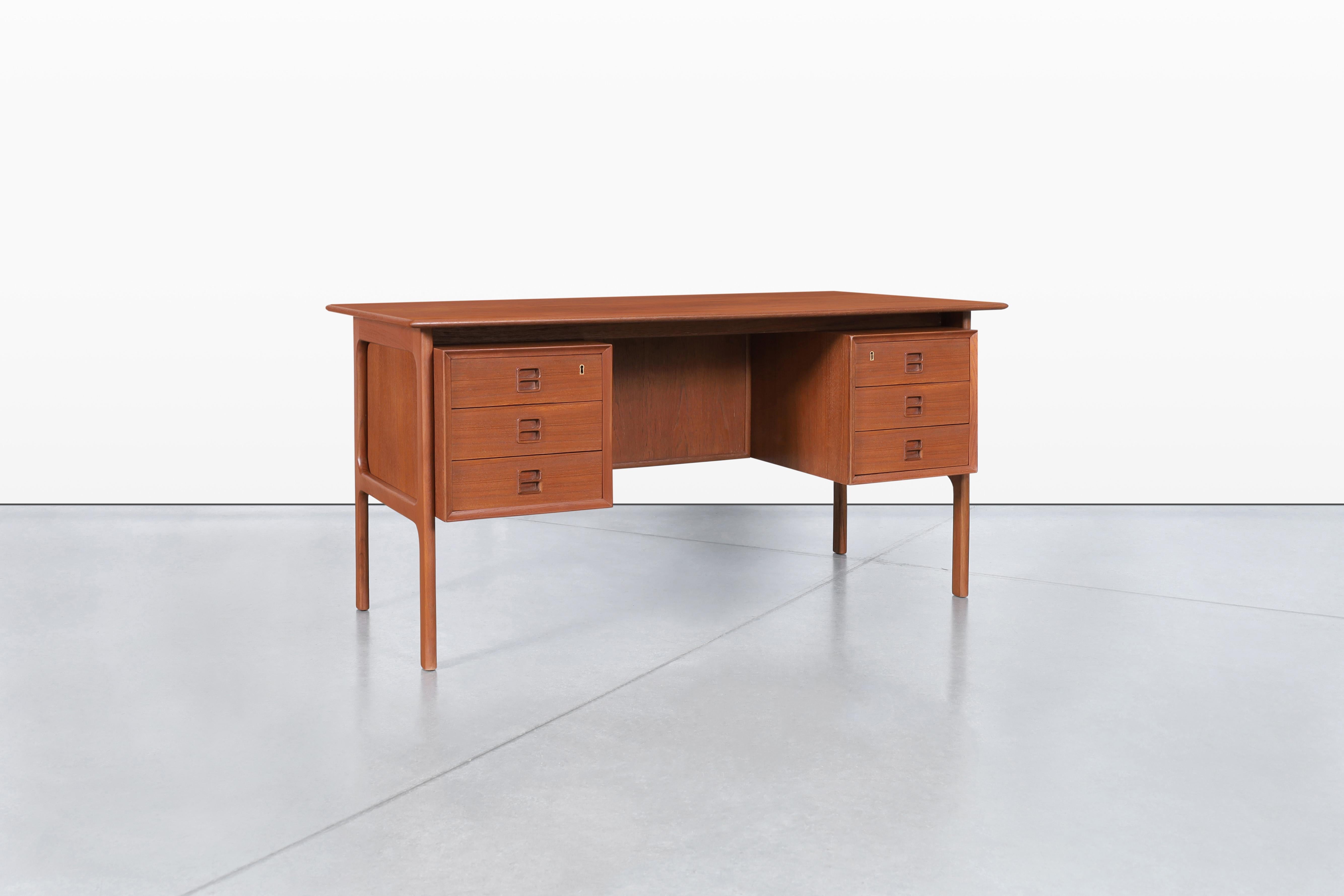 Dieser exquisite dänische Schreibtisch aus modernem Teakholz, der in den 1960er Jahren von Erik Brouer für die Brouer Møbelfabrik entworfen wurde, zeigt die Essenz der dänischen Handwerkskunst. Die eleganten, handgefertigten Griffe verleihen ihm ein