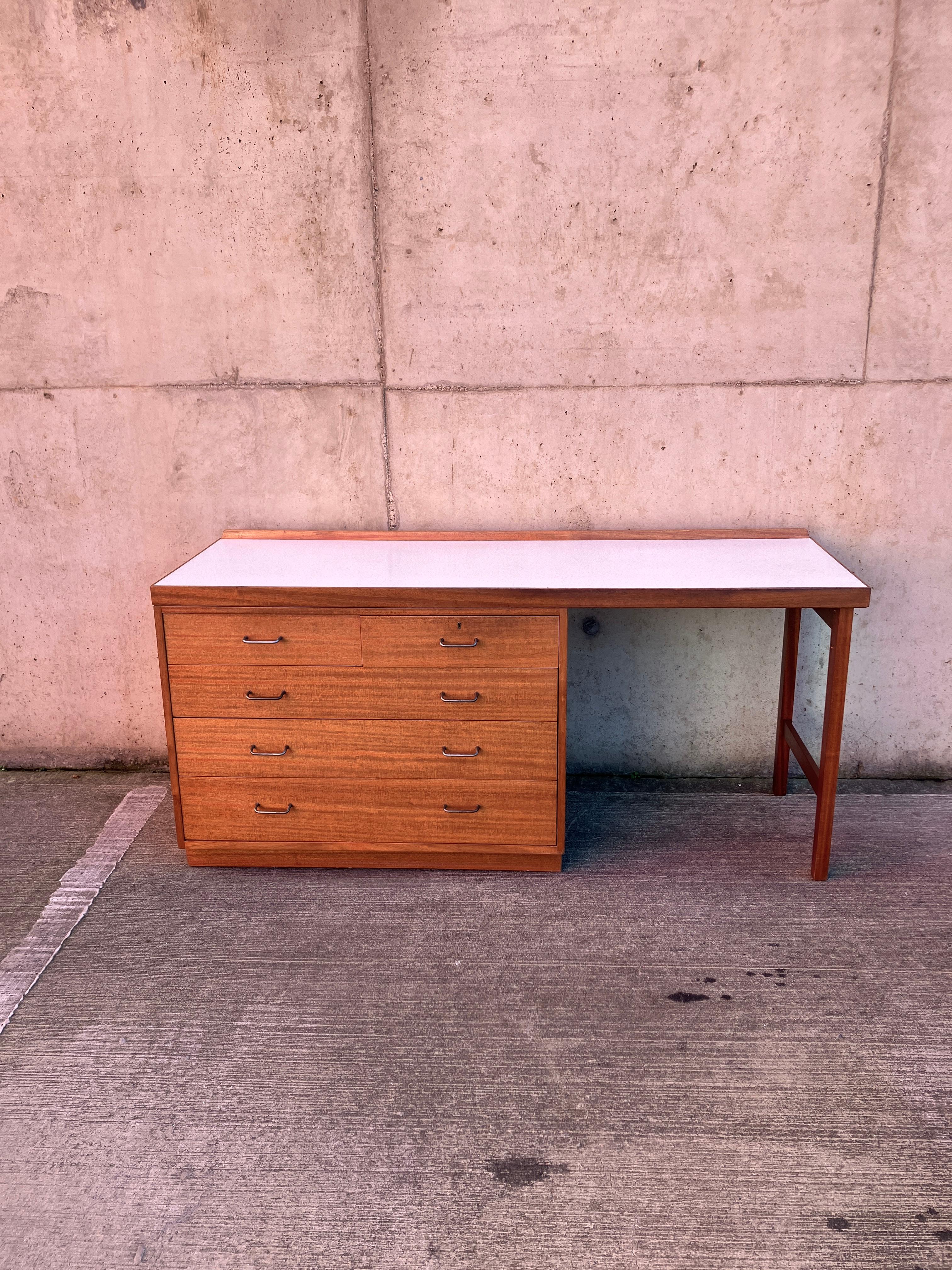 A fabulous Mid Century modern sideboard / desk with drawers unit in Teak. This sideboard has five drawers, four large ones and two small ones on top. Elegant metal handles. The desk top is finished with a beautiful and hardwearing Formica with an