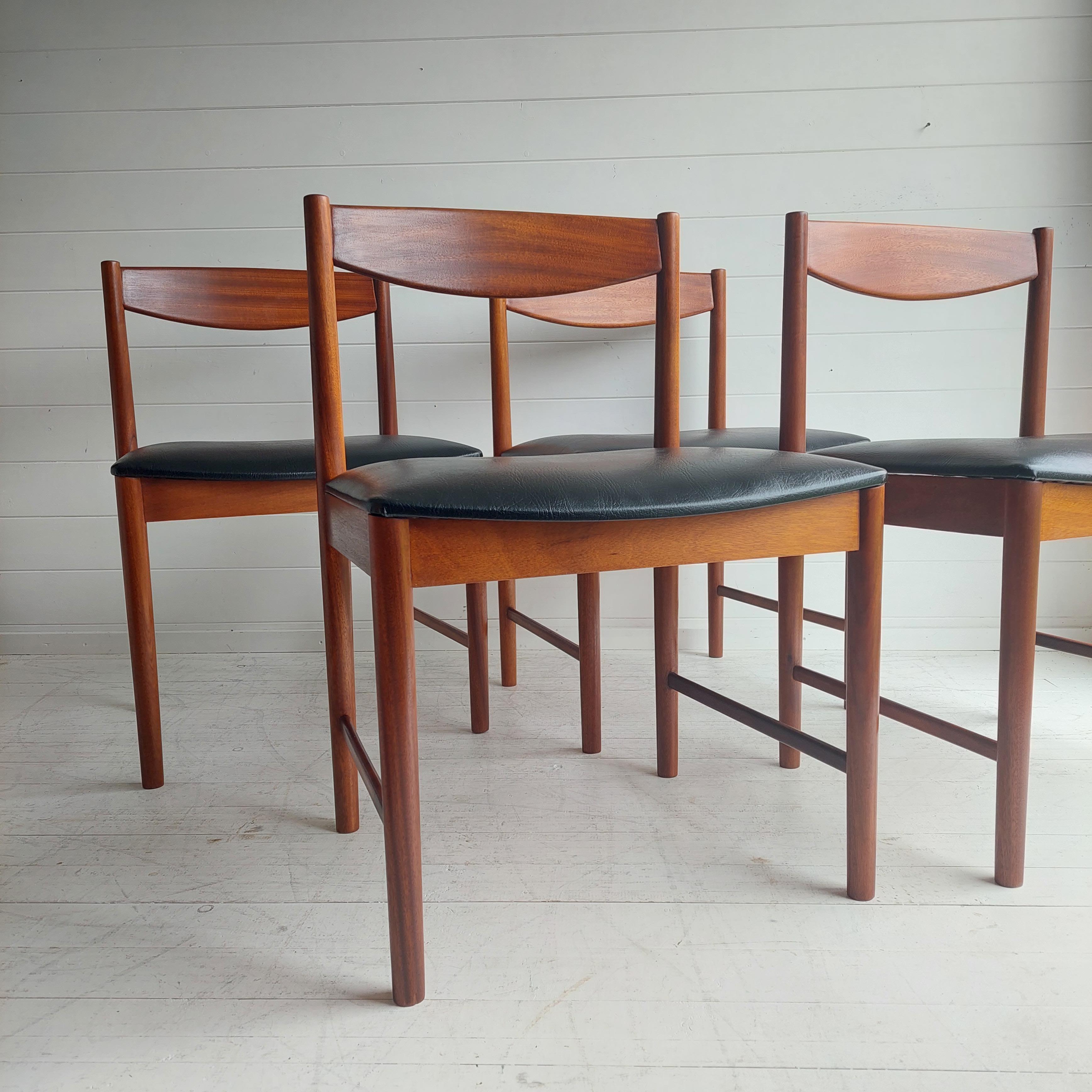 A fantastic set of four dining chairs designed by Tom Robertson in the 1970's for A.H McIntosh.
A set of four midcentury dining chairs by McIntosh made in teak with newly upholstered black vinyl seats.

The dining chairs are a simple midcentury