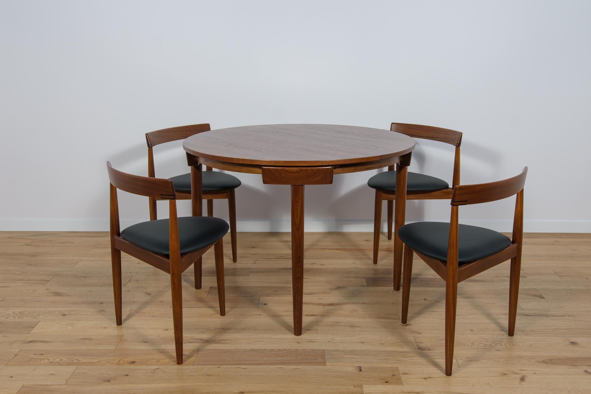 Manufactured by Frem Rojle in Denmark and designed by Hans Olsen. The chairs feature a teak frame with a triangular seat upholstered in black new natural leather. The woods items have been cleaned from the old surface and painted oak stain and
