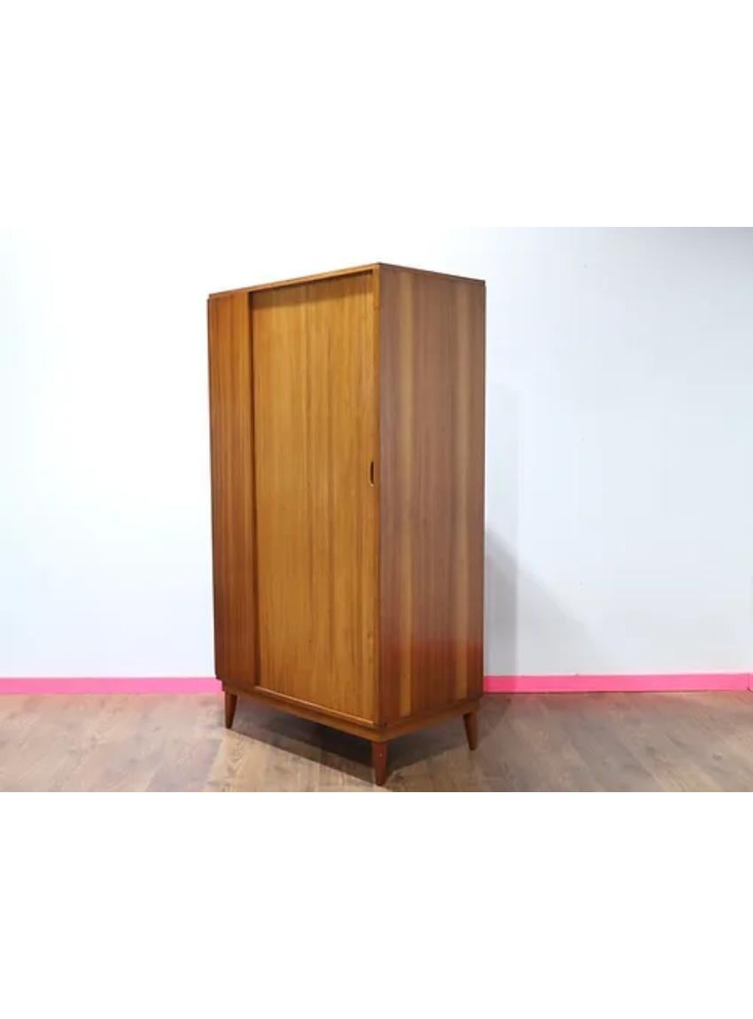 This gorgeous Mid Century Armoire is a perfect example of a MCM British design classice, featuring a sliding tambour door which really sets this piece off.  The main compartment features a hanging rail and adjustable shelves.  This is gorgeous piece