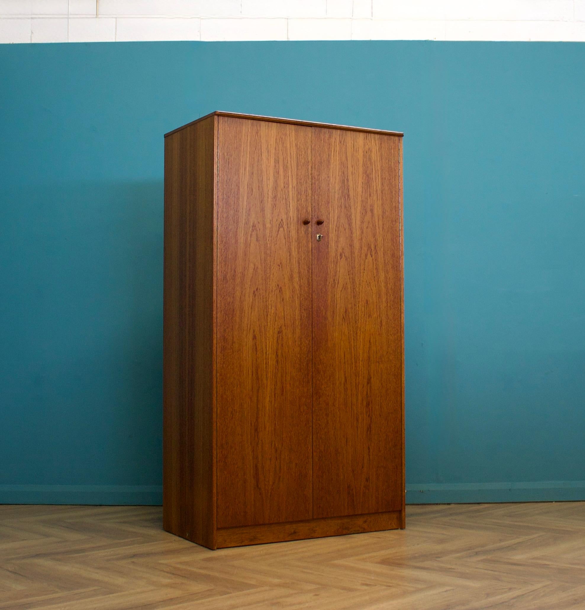 A freestanding double door teak wardrobe
Made during the 1960s

A freestanding double door teak wardrobe
Made during the 1960s

Fitted out with a clothes rail and shelves
The style of this wardrobe is quite minimalist - with it's clean