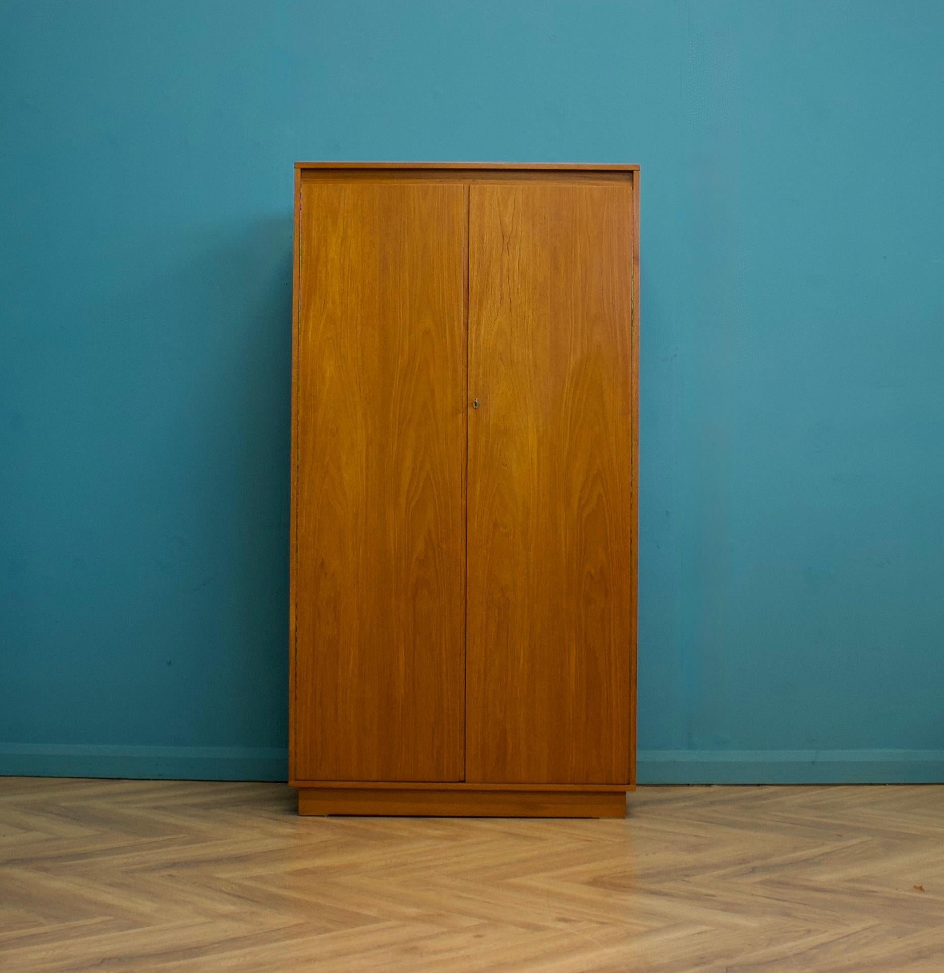 Ein freistehender zweitüriger Teakholz-Kleiderschrank von Wrighton
Hergestellt in den 1960er Jahren

Ausgestattet mit zwei Kleiderstangen und Regalen
Der Stil dieser Garderobe ist ziemlich minimalistisch - mit seinen klaren Linien

Der passende