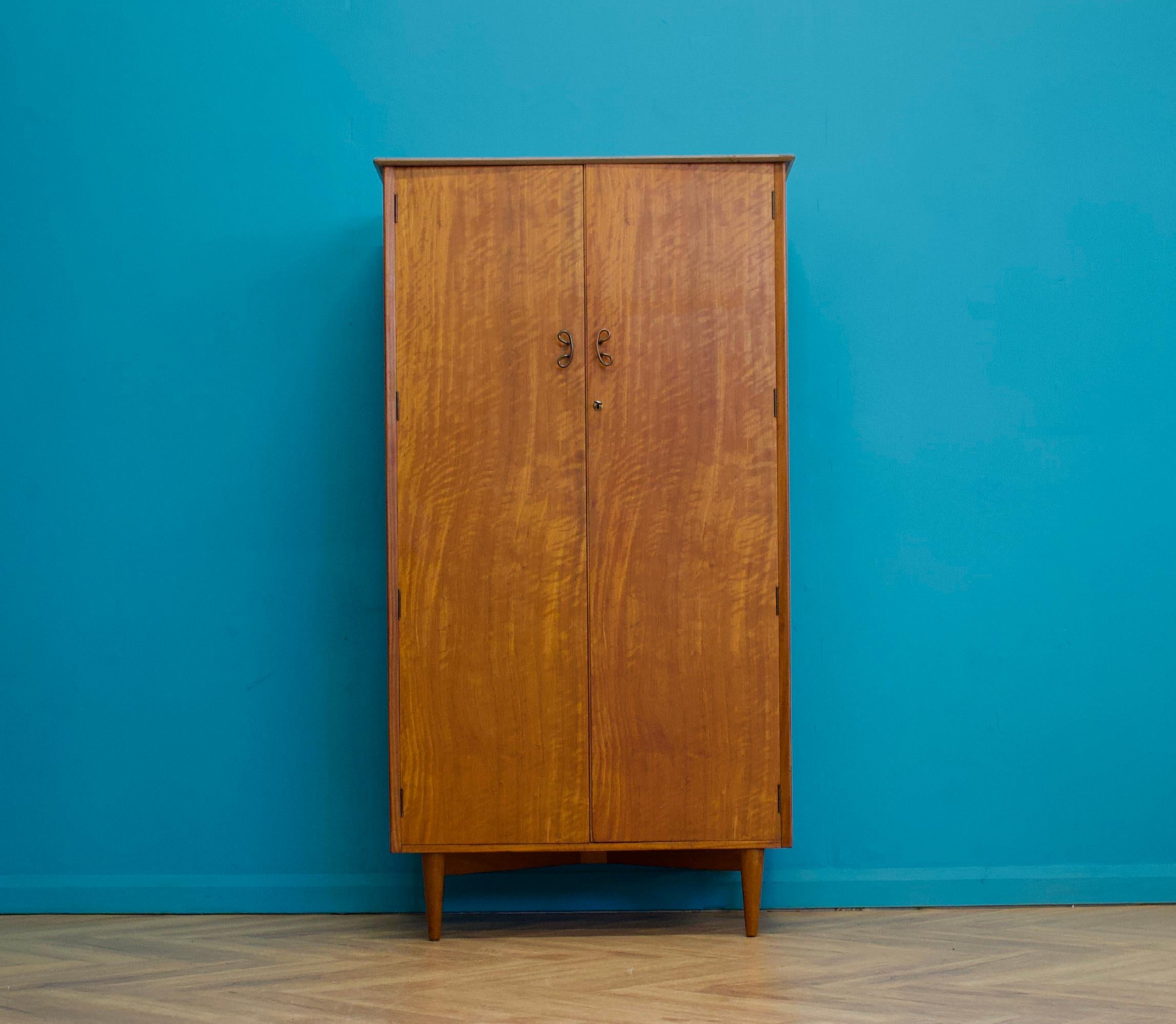 A freestanding double door teak wardrobe from Younger
Made during the 1960s


Fitted out with a clothes rail, shelves and drawers


Featuring metal handles


There's  a matching larger wardrobe listed separately


