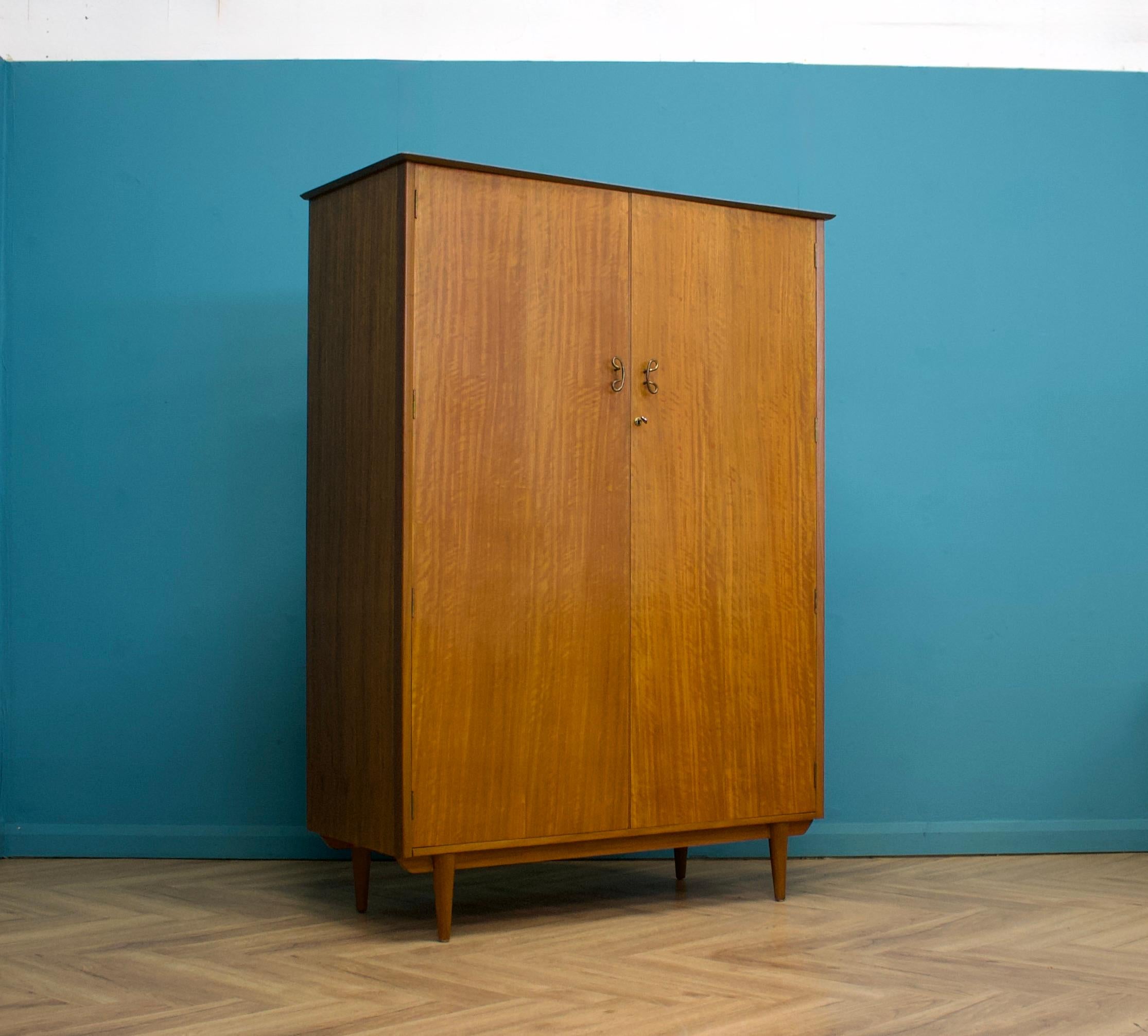 Un armadio indipendente a due ante in teak di Younger
Realizzato negli anni '60


Dotato di appendiabiti
Caratterizzato da maniglie in metallo





