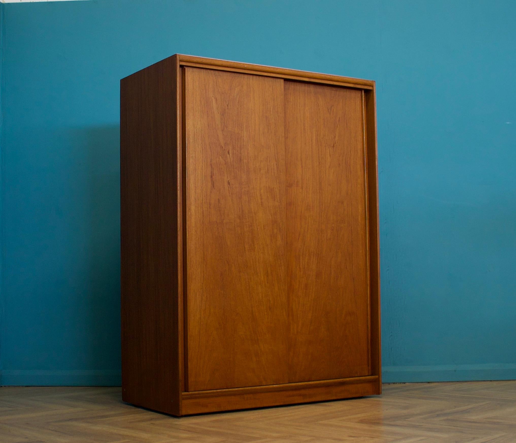 A freestanding double door teak sliding door wardrobe from Austinsuite
Made during the 1960s

Fitted out with clothes rail
The style of this wardrobe is quite minimalist - with it's clean lines
This wardrobe can be dismantled