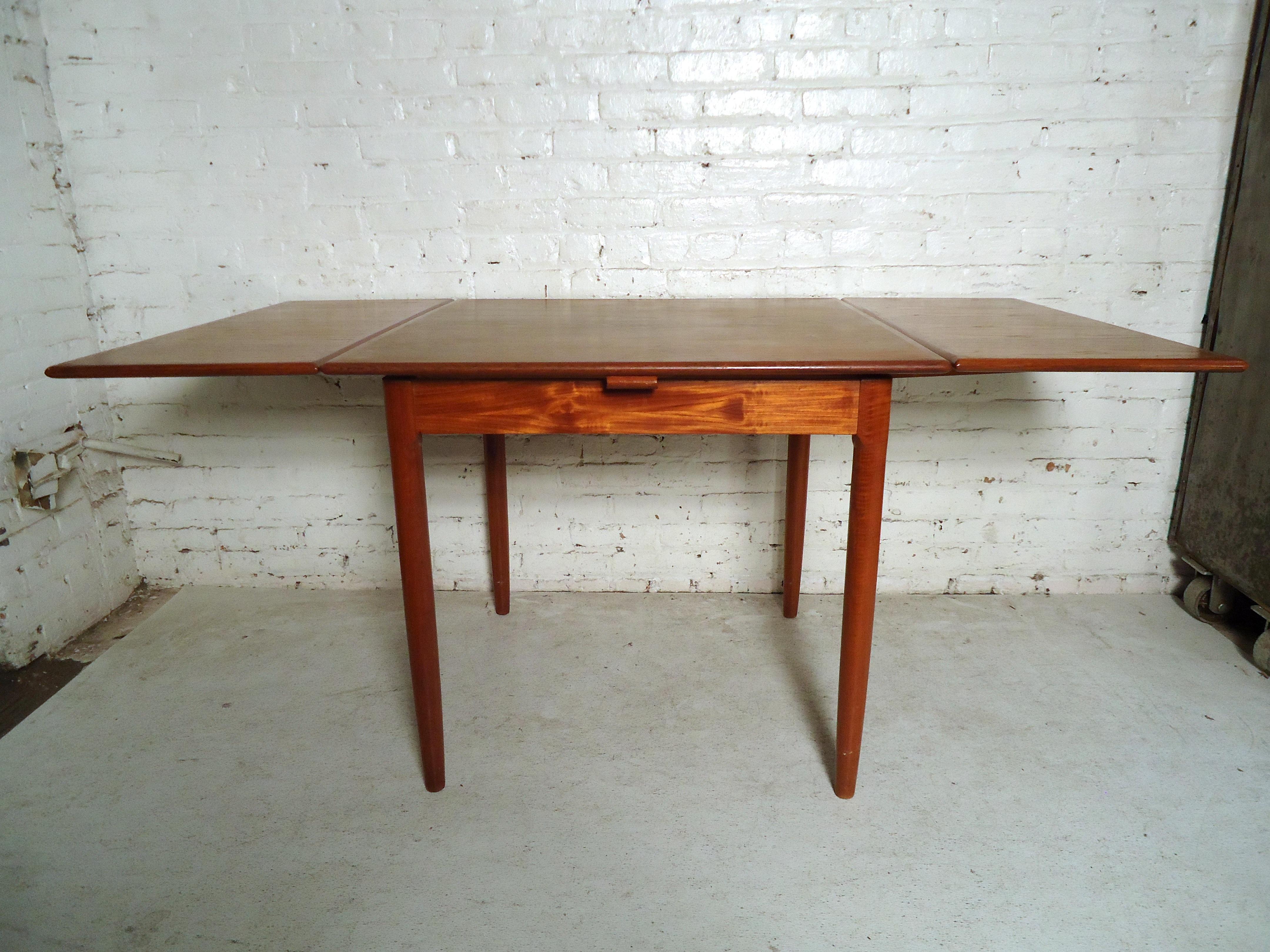 Vintage modern square teak drop-leaf table featuring tapered legs. This extendable table would make a great addition to any home.



 