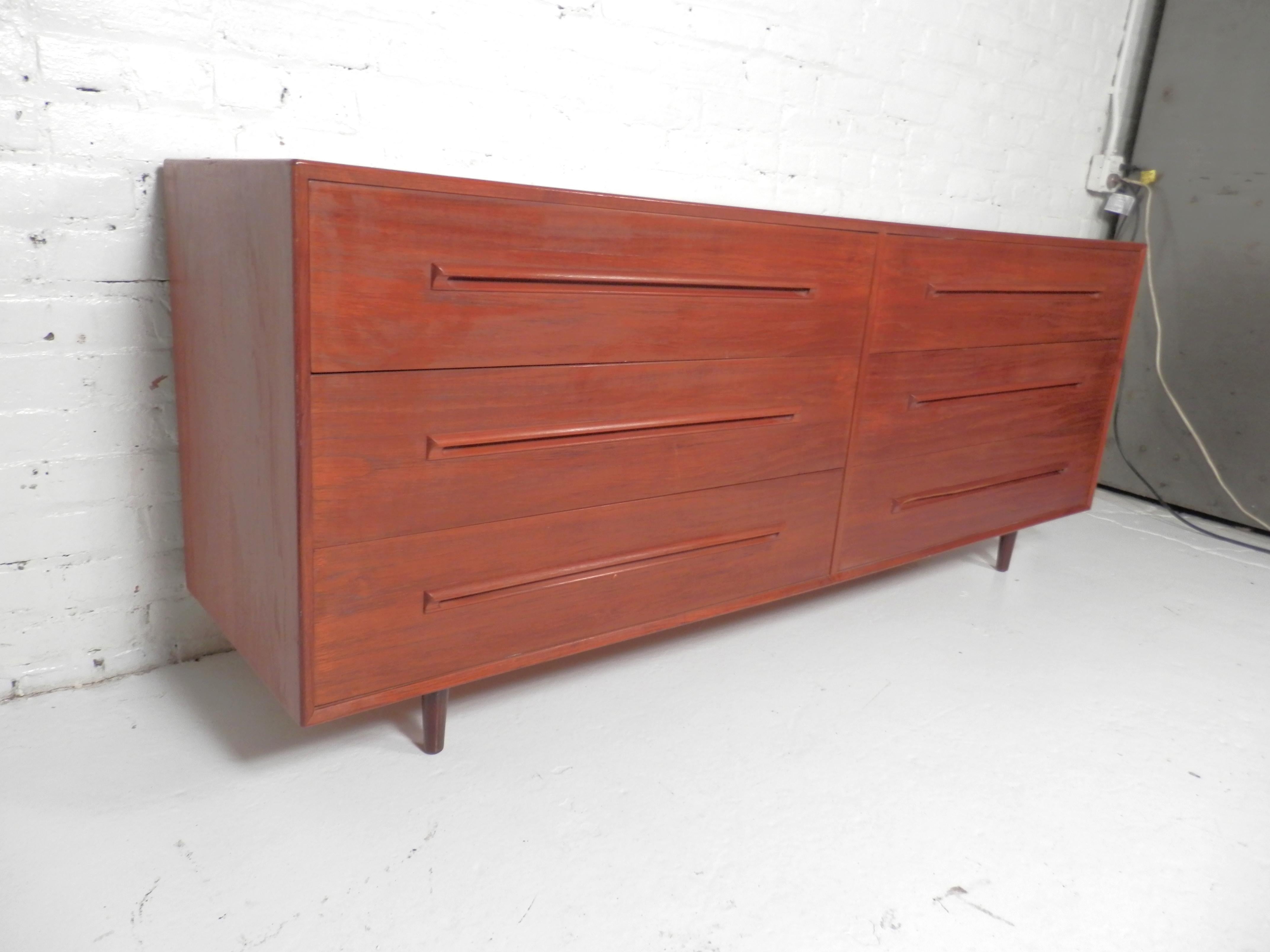 Sleek Mid-Century Modern double dresser by Westnofa. All teak grain six drawer dresser with sculpted wood handles and tapered legs.
Please confirm location.
 