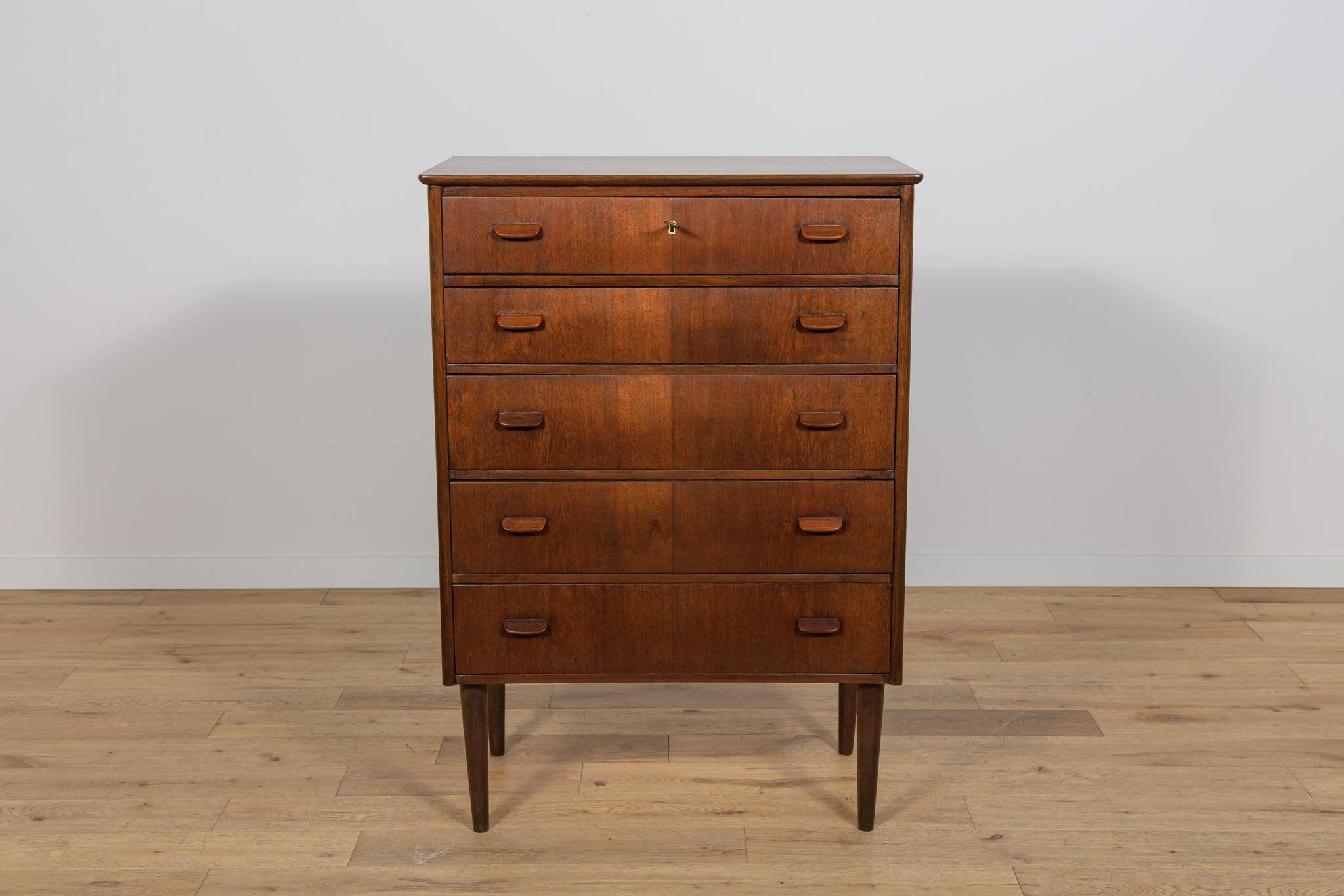Comò in teak con cinque cassetti prodotto in Danimarca negli anni '60. I mobili sono stati sottoposti a una ristrutturazione completa della falegnameria. Il comò è stato ripulito dal vecchio rivestimento, verniciato con mordente per palissandro e