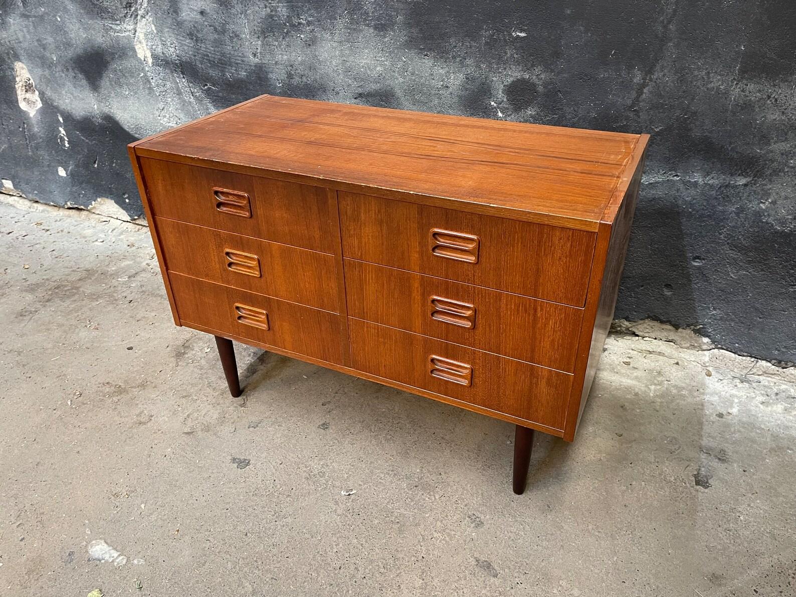 Add a touch of timeless style to your space with this stunning vintage mid-century modern dresser. Featuring 6 spacious drawers with iconic sculpted pulls, sleek tapered legs, and a rich wood finish, it's the perfect blend of form and function.