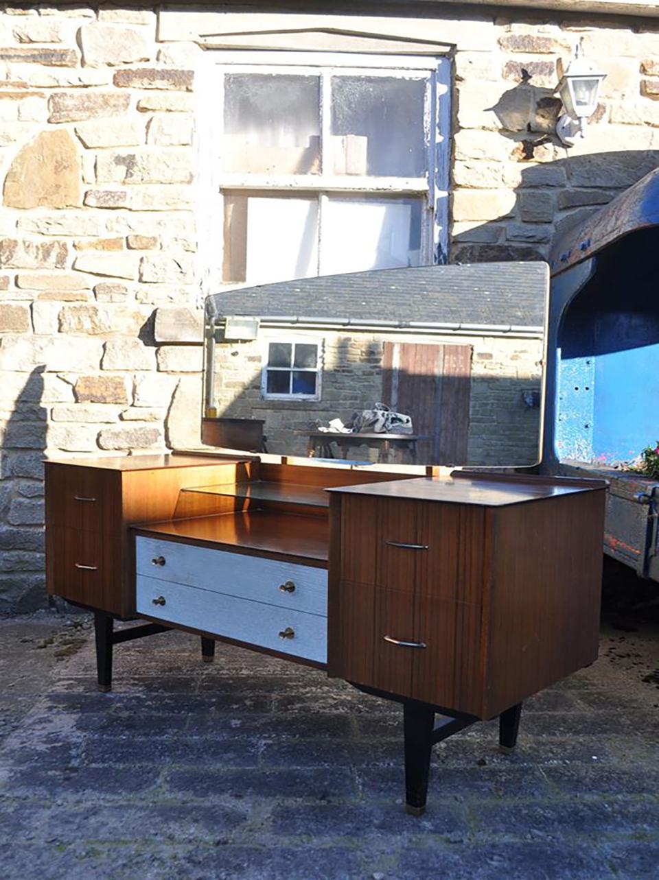 Midcentury teak dressing table, 1960s.
With black shaped legs, with original brass feet!, large mirror, which is in exceptional order, glass shelf below mirror, in good condition.
Measures: 53 inches width, 19 inches depth, 27 inches counter