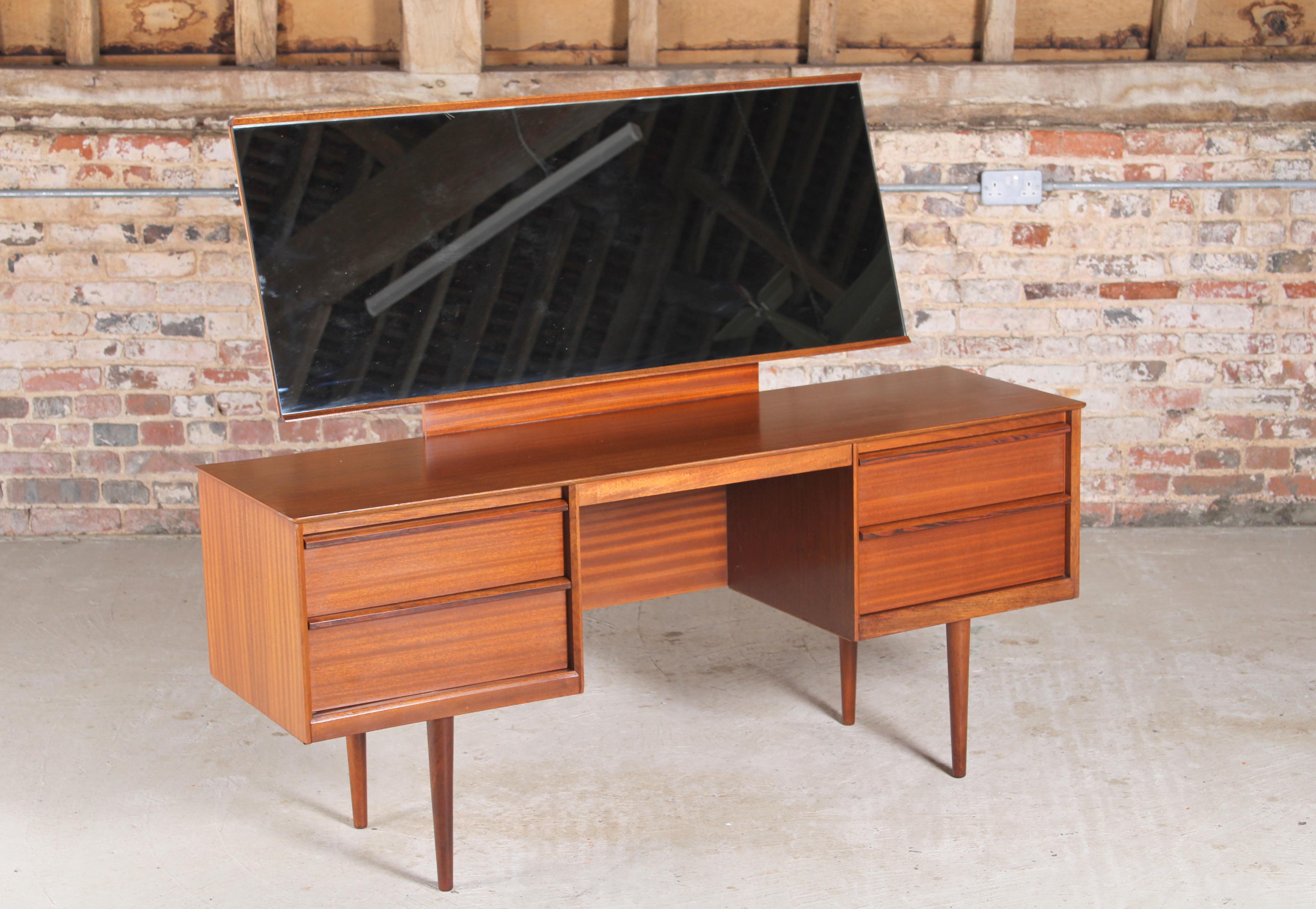 Mid century teak dressing table by Austinsuite, England, circa 1960s. 4 drawers with solid rosewood handles and an angle adjustable mirror. 

Measures: W 149cm
D 44cm
H 122cm
Table height 66cm.