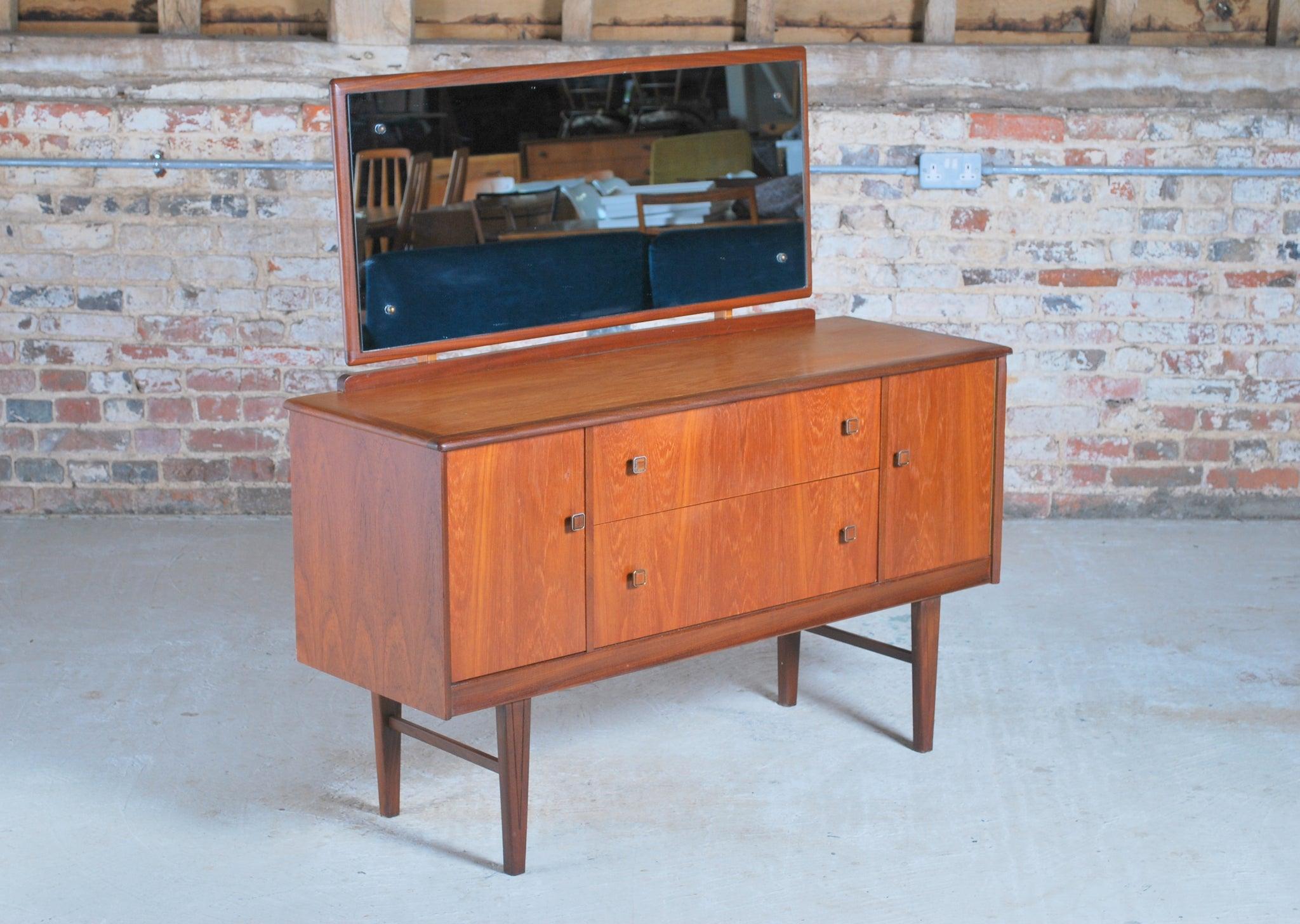 Mid century teak dressing table by Homeworthy, England, circa 1960s. 3 drawers and 2 cabinets. Mirror and mirror mounts can be removed.

Dimension: W 123cm x D 42cm x H 121cm
Chest height: 72cm.