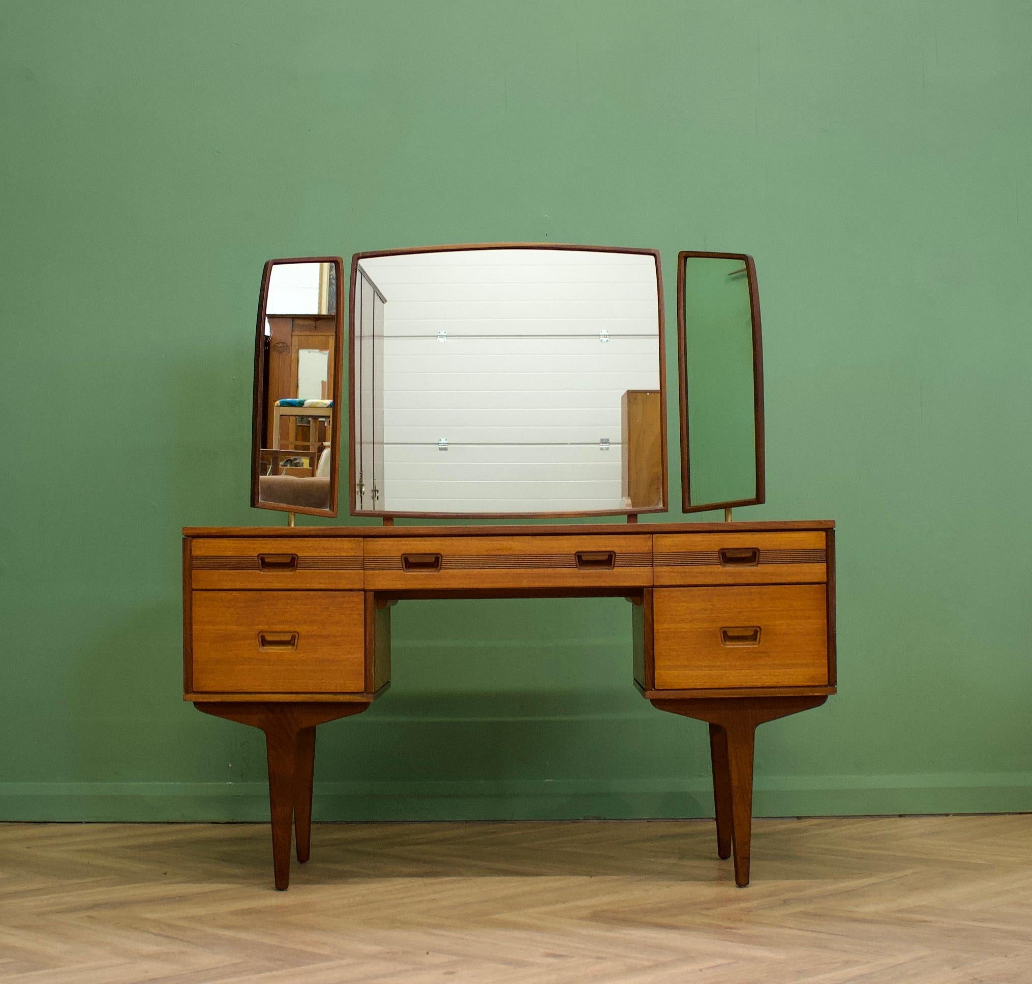 A mid century teak dressing table from Butilux - a little known about  high quality furniture makers, circa 1960's
Complete with a triptych mirror - all three are adjustable either by tilting or swiveling - the two side mirrors are held by brass