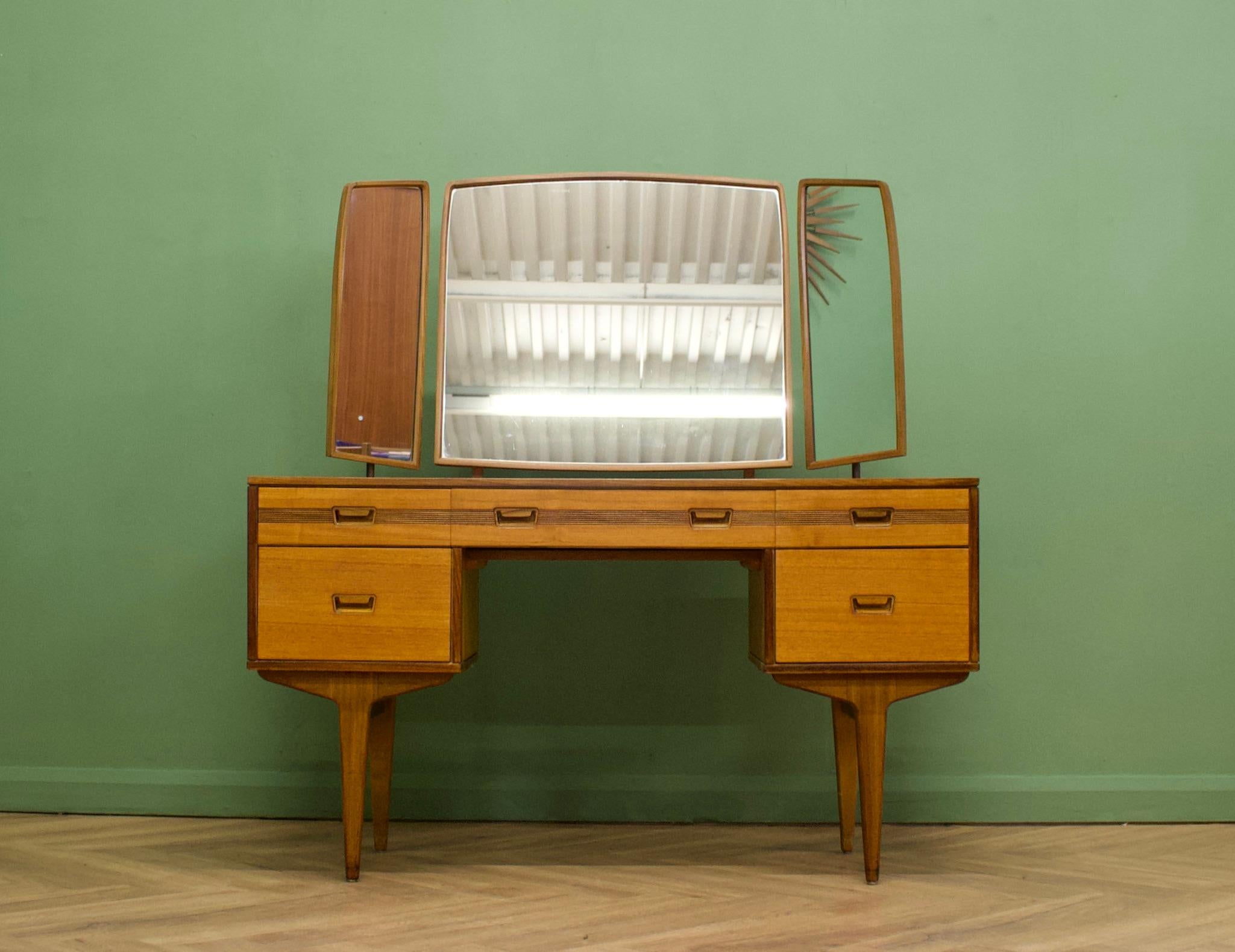 A mid century teak dressing table from Butilux - a little known about high quality furniture makers, circa 1960's
Complete with a triptych mirror - all three are adjustable either by tilting or swiveling - the two side mirrors are held by brass