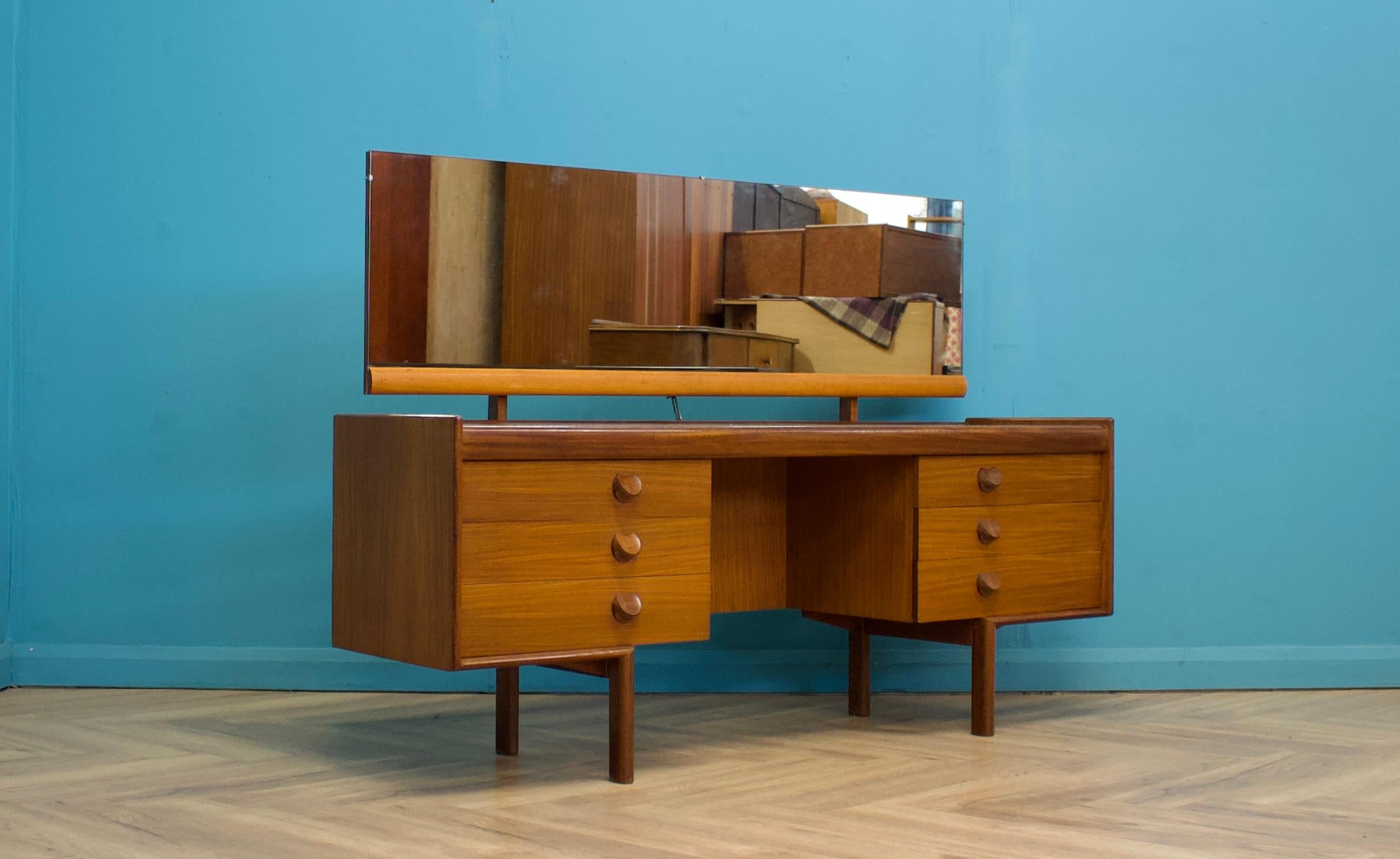 A mid century teak dressing table from White and Newton, circa 1960's
Complete with a mirror
There are six drawers in total -  The handles are solid teak
The piece stands on solid teak legs, which are very sturdy and solid


The height to the top of