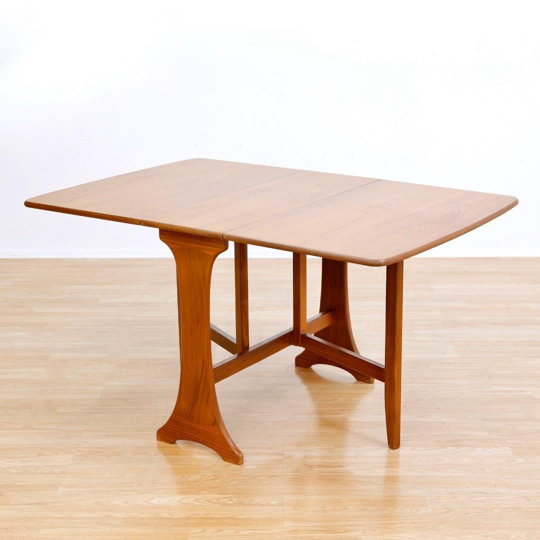 This mid-century drop leaf dining table was produced by G Plan in England during the 1960s. Made from teak with two folding leaves it is a beautifully designed classic piece of mid-century British design.