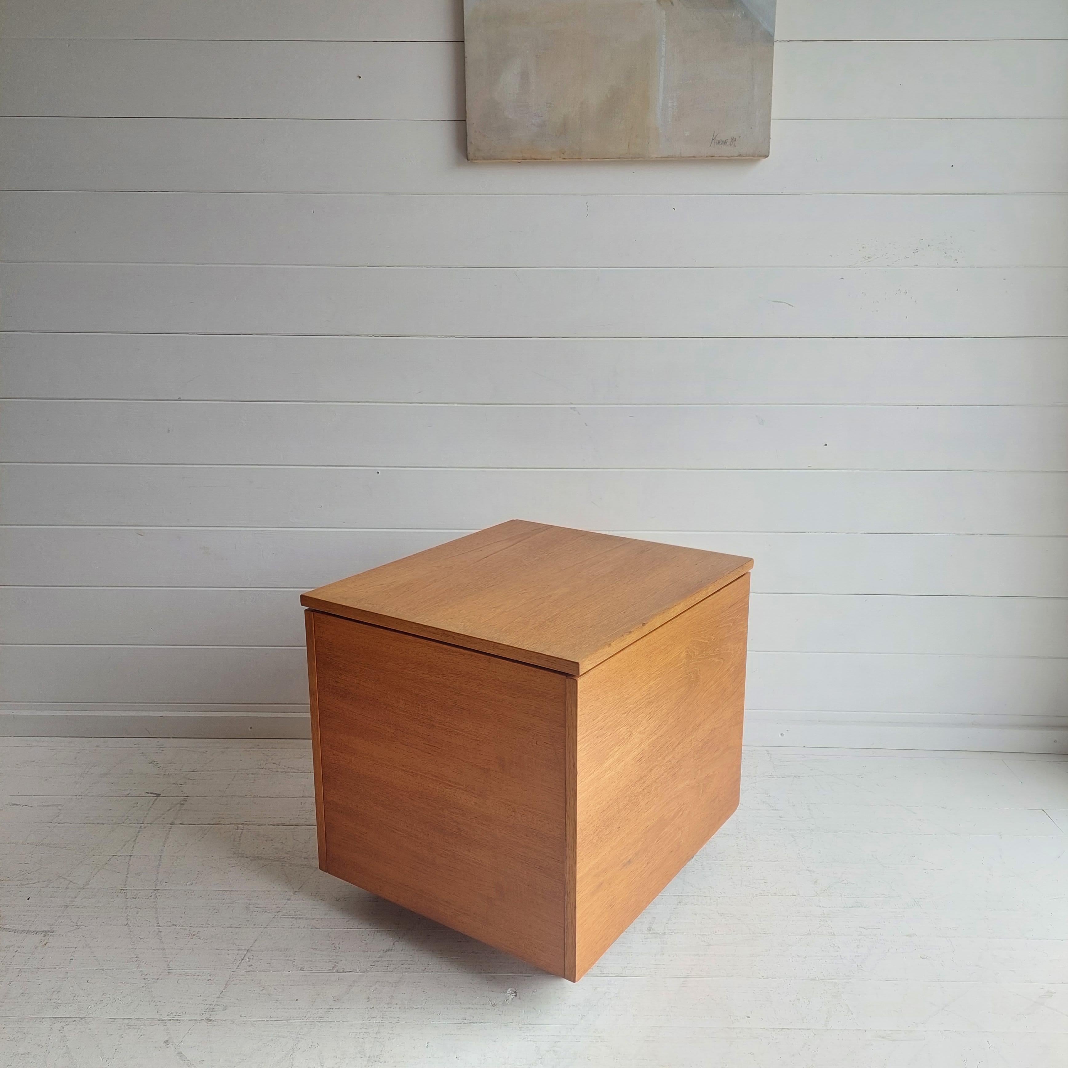 A teak record cabinet box by Ellitos of Newbury
Design Period - 1960 to 1969
Style - Mid-Century

This nearly square shaped piece has lost of possibilities: Side table, Nightstand, ottoman......
It features: 
Cube design 
Wheels for easy