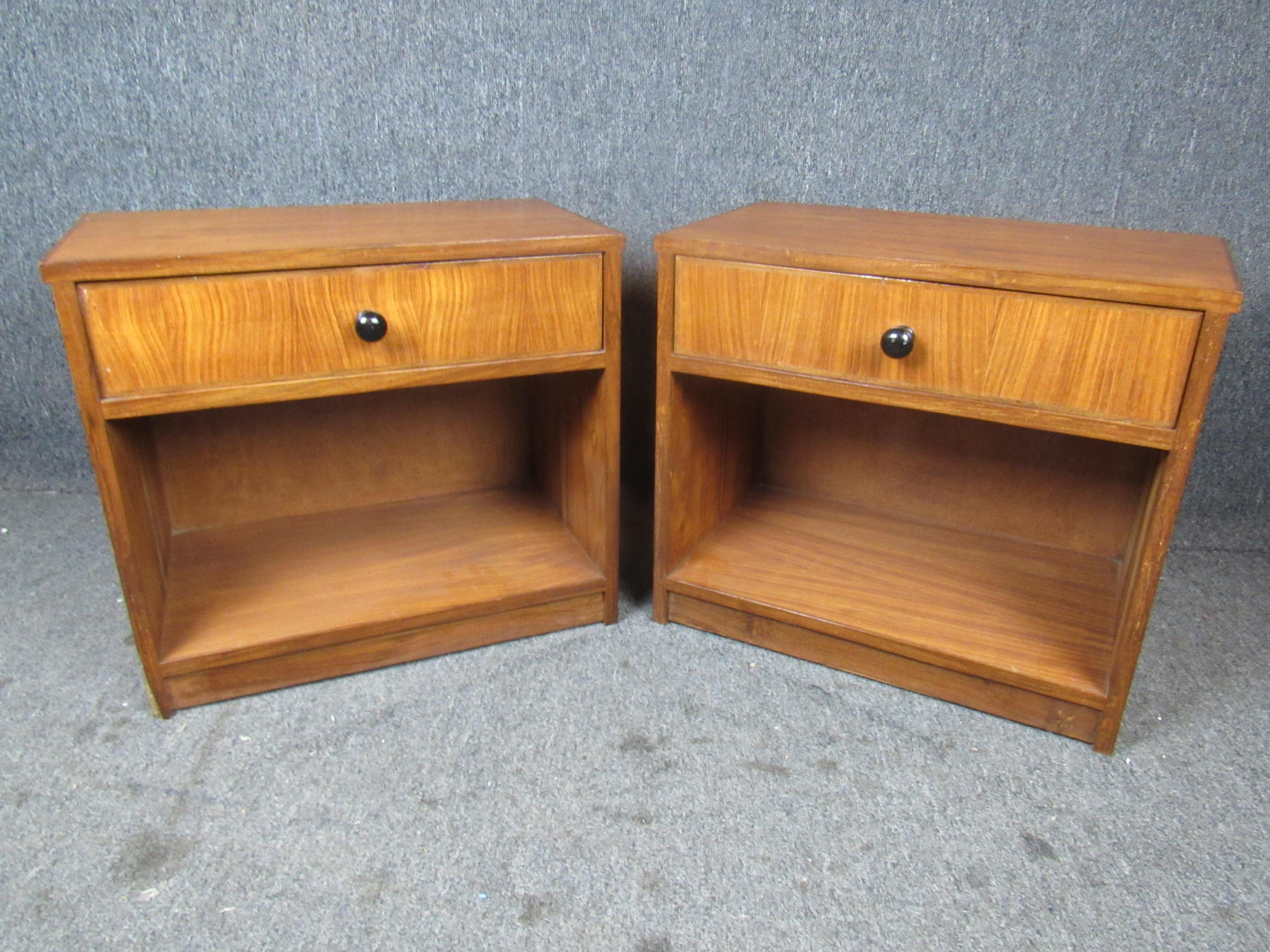 Pair of Mid-Century Modern night stands. Classic midcentury look featuring open storage on the bottom, pull drawer on top, and black spherical pull handles.