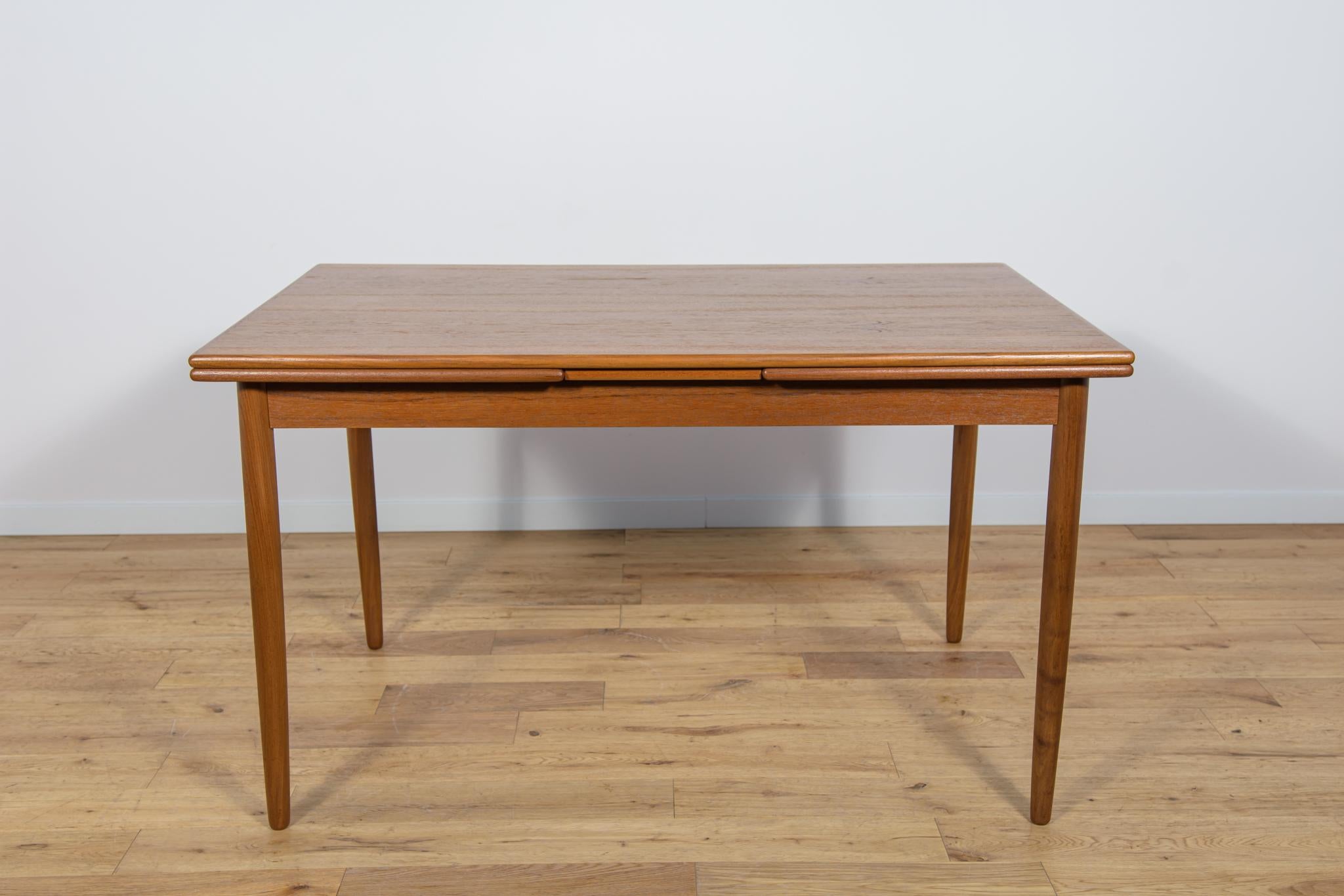 This Mid-Century extendable dining table in teak was manufactured in the Denmark the 1960s. The table has reinforced, profiled edges, giving it elegance. The teak elements have been cleaned from the old surface and painted  oak stain and polished