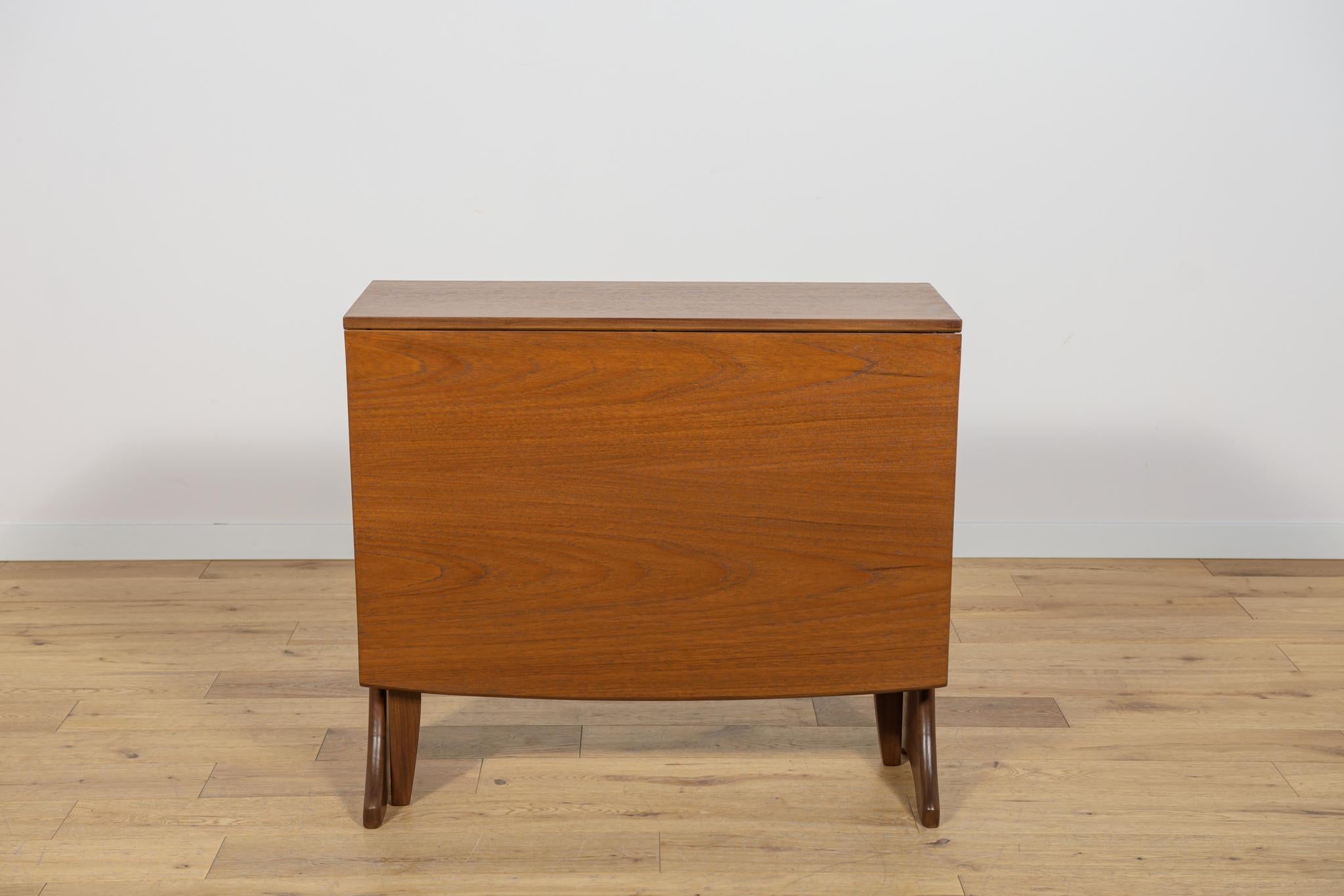 Questo tavolo da pranzo in teak risale agli anni '60. Il tavolo è prodotto da G-Plan nel Regno Unito. Gli elementi in teak sono stati ripuliti dalla vecchia superficie e verniciati in tinta Oak, rifiniti con una robusta lacca semilucida. Prima di