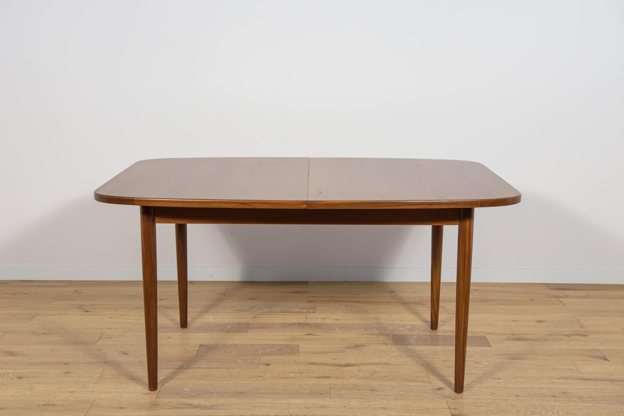 This is an rectangular shaped teak dining table manufactured by G-Plan in the 1960s. The table has reinforced edges of the top. The teak elements have been cleaned old surface and painted oak stain and finished with a strong semi-matt varnish. The