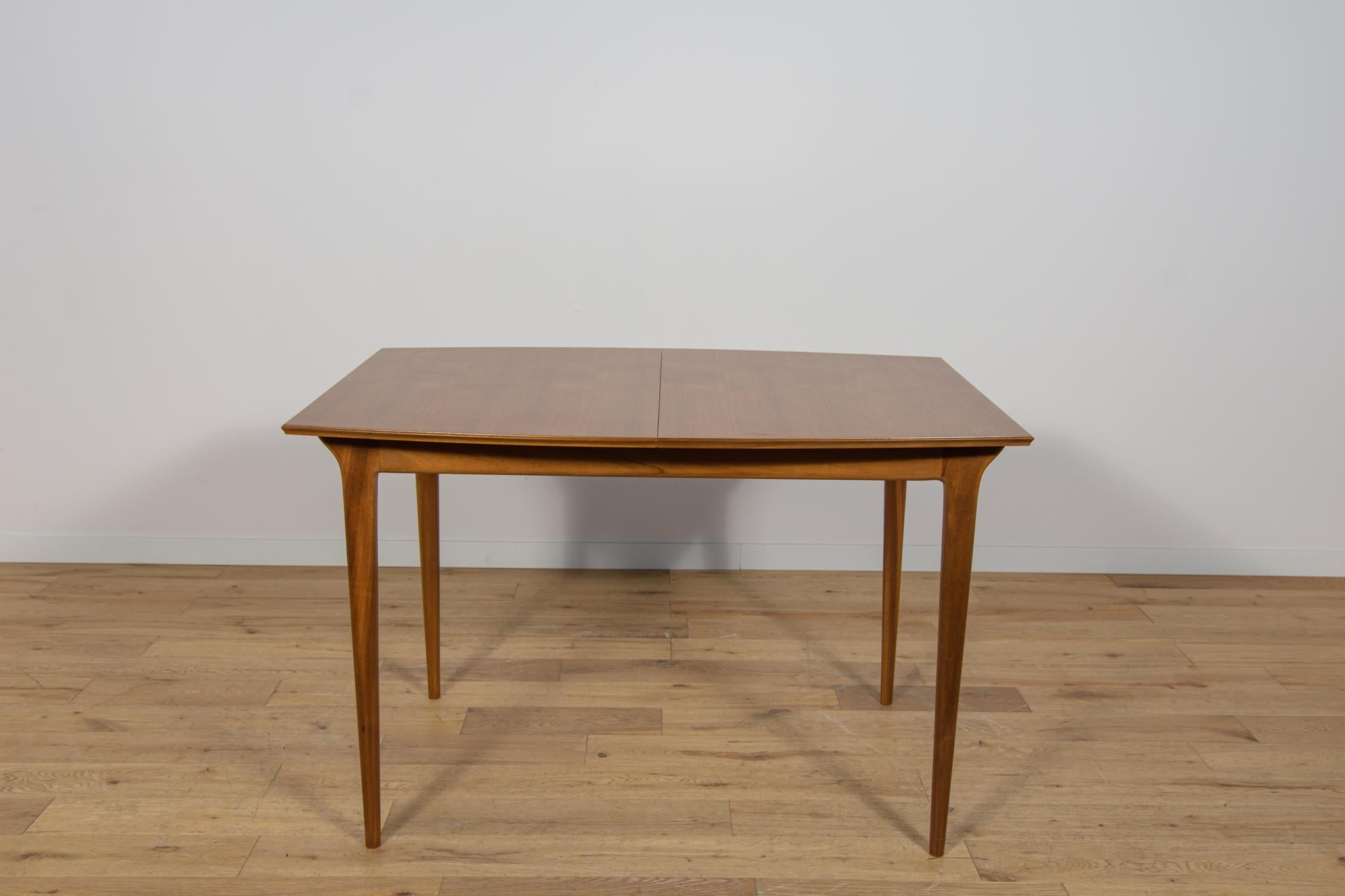The rectangular  table produced in the 1960s in Scotland by A.H. McIntosh. It is made from teak. The furniture has profiled legs, giving it a unique character and elegance The old surface has been cleaned, painted in oak stain and polished with