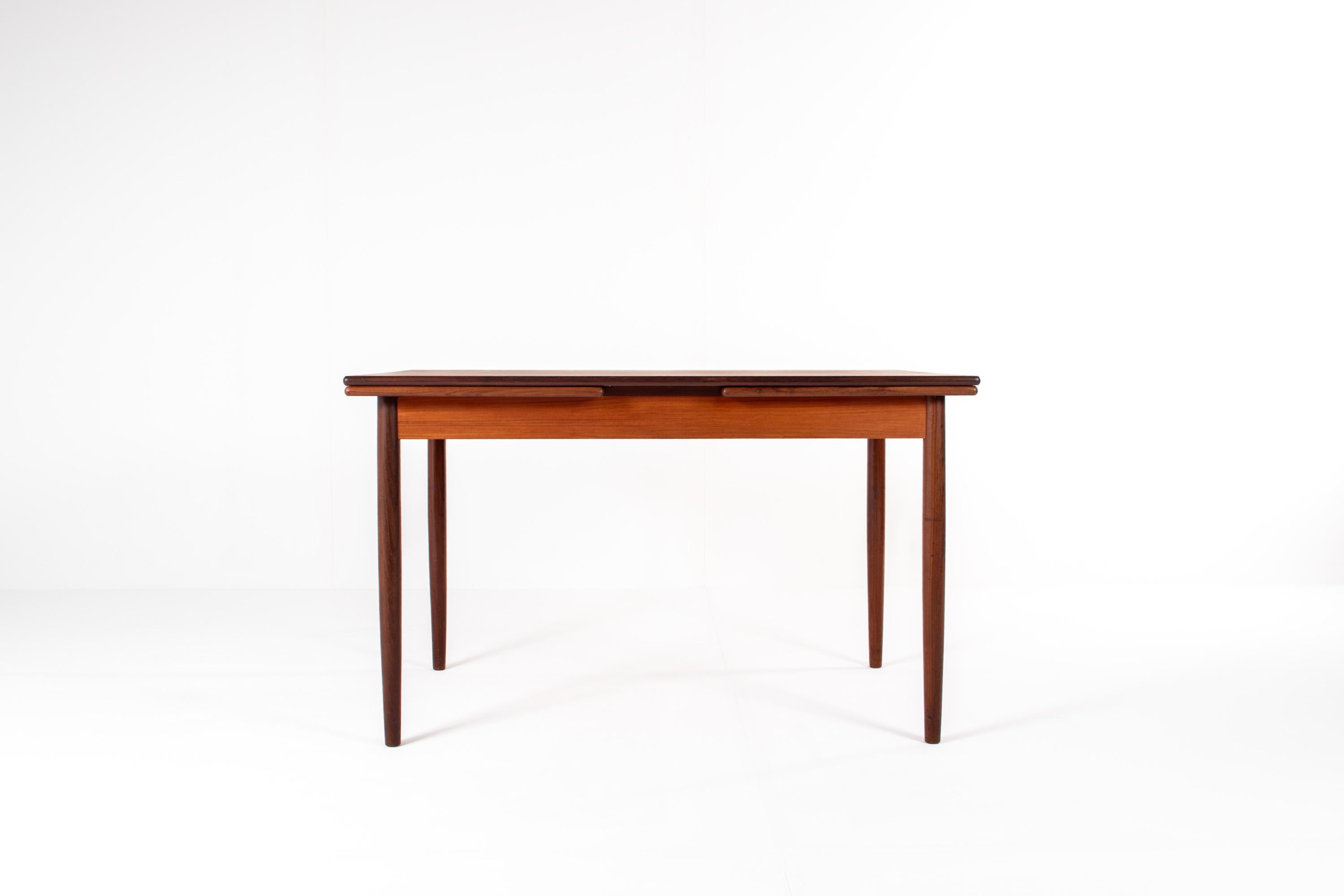 A beautiful mid-century Scandinavian teak extendable dining table from the 1960s. This elegant piece features a warm teak tabletop with clean, minimal lines and two integrated pull-out extension leaves, allowing the table to expand effortlessly when