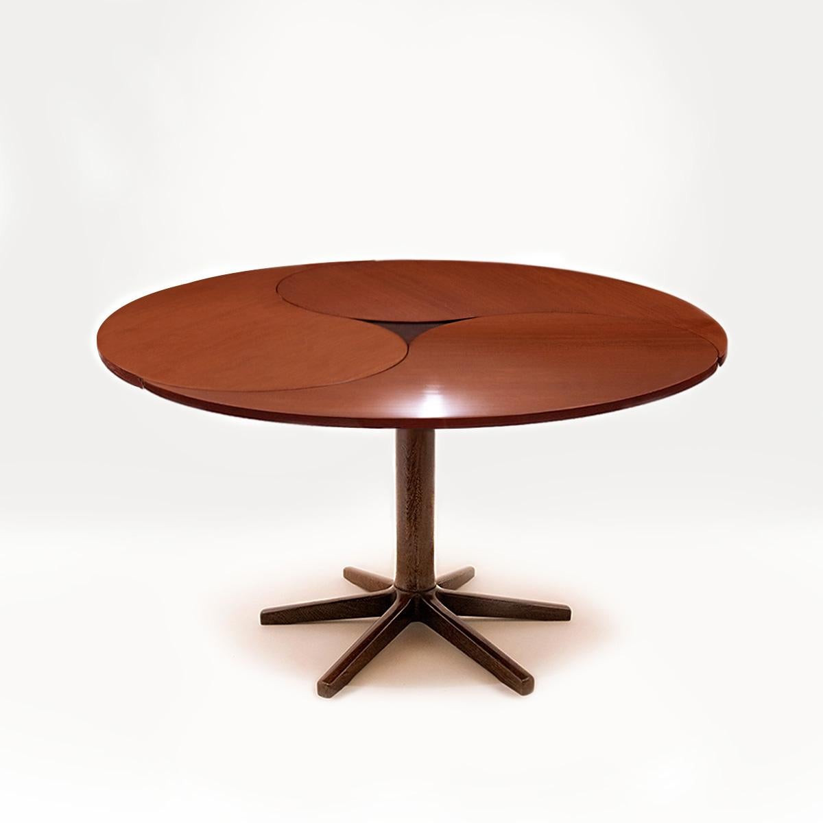 An extraordinary Danish Mid Century vintage teak and wenge Model 550 space saving dining table designed by Ole Gjerløv-Knudsen and Torben Lind for France & Son.

This design takes its name from the pivoting and rotating comma shaped leaves that