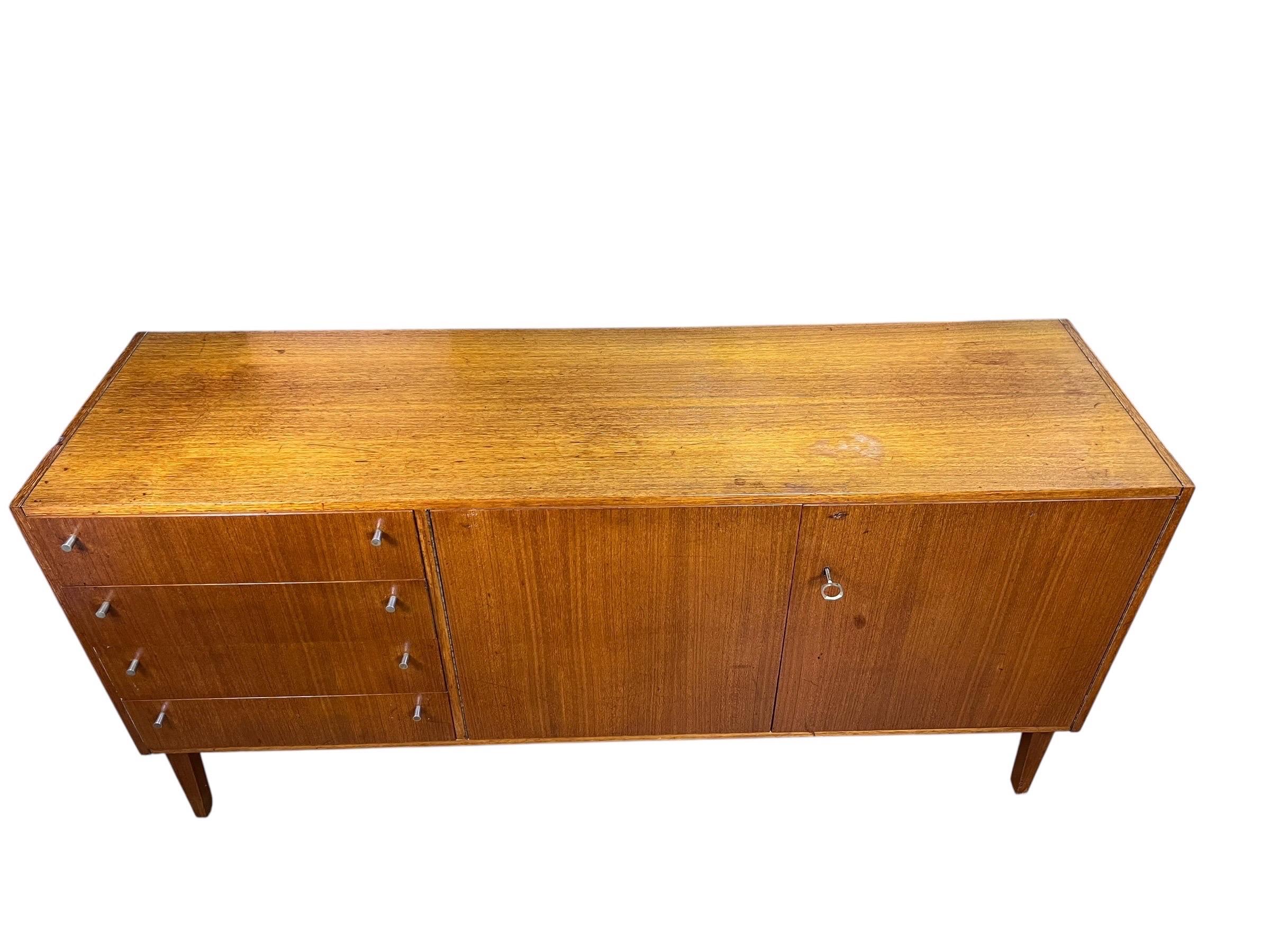 In vendita c'è questa bellissima credenza in teak. La credenza è composta da 4 cassetti con due ante. Il pezzo ha ancora la sua chiave scheletrica originale.
