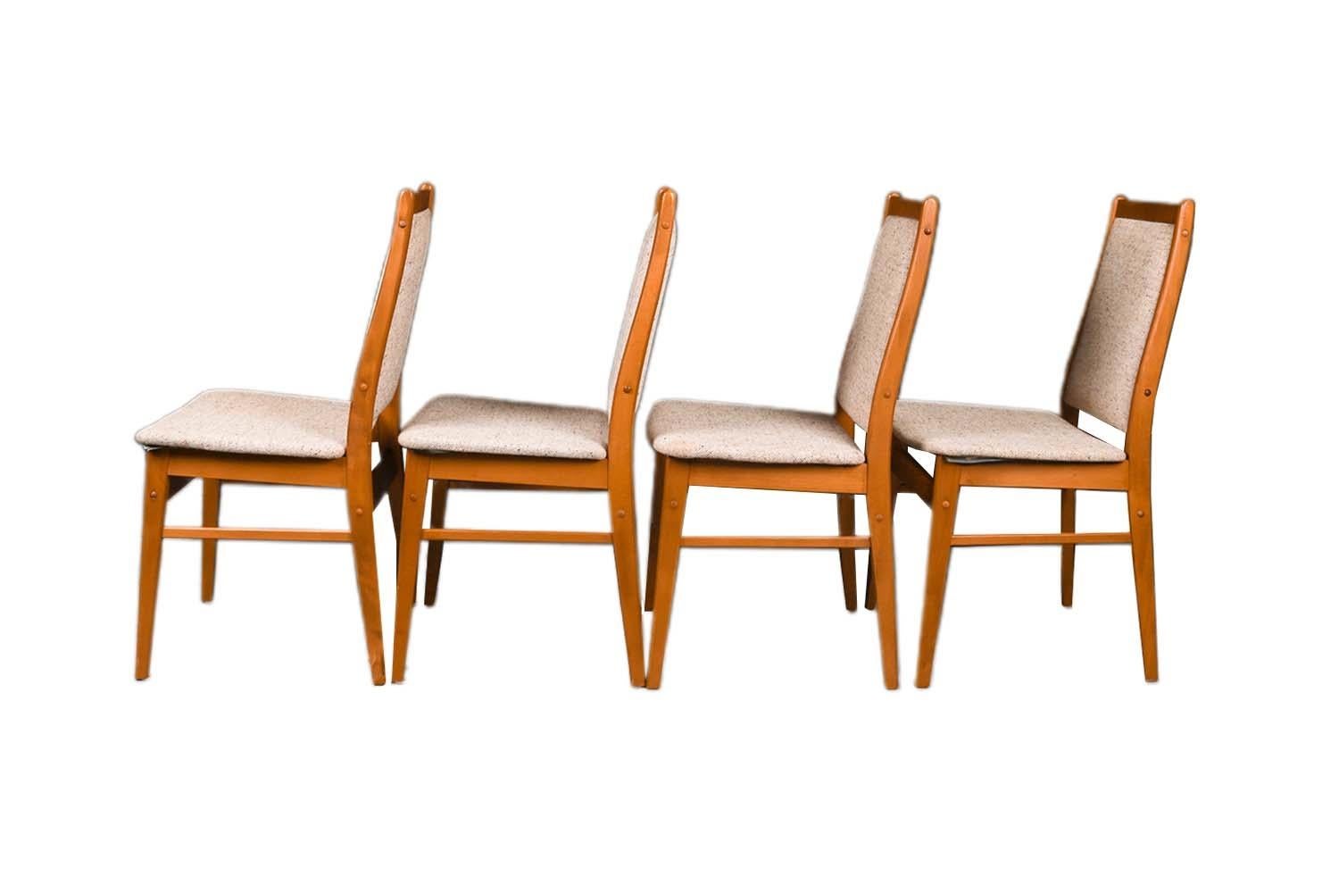 A set of four, extremely sought after, gorgeous 1960s, modern teak side/dining chairs. Featuring a full matching set of four, each remains in original condition throughout. Features teak frames, with padded high backrests, and padded seats, retain
