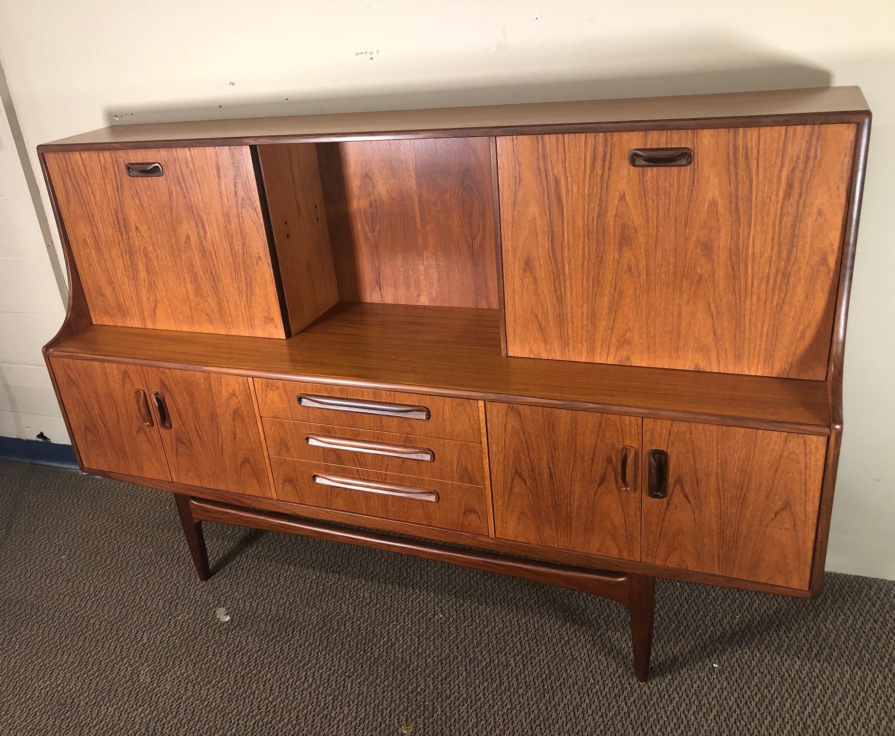 Mid-Century Modern versatile high board by G Plan. Featuring a sliding door and a small drop down desk that can comfortably hold a laptop or be used as a wine bar. 

Exceptionally nice wood grain on this piece. Very well taken care of. Small paint