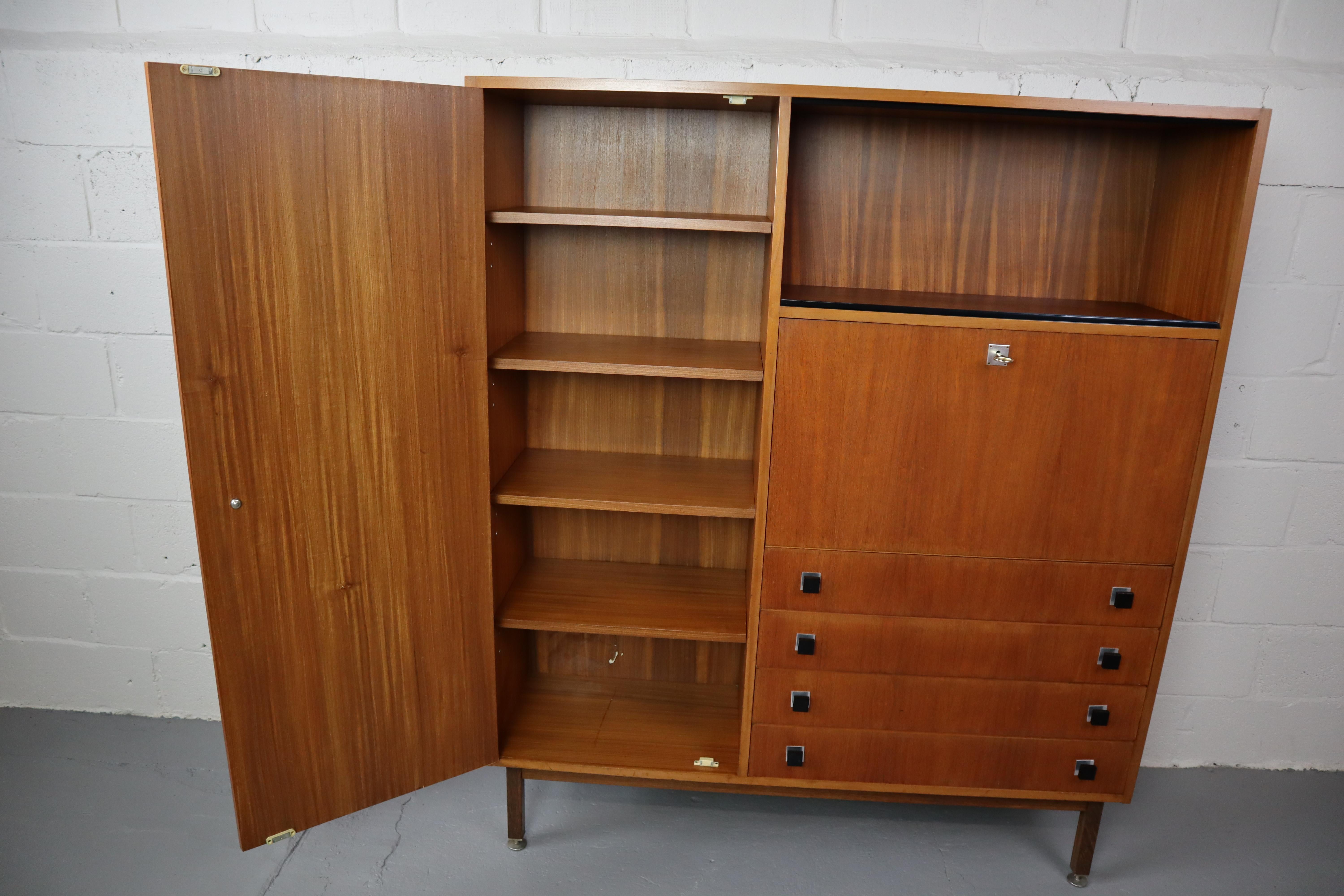 Vintage teak highboard from Combineurop Belgium, 1960's. This cabinet has 4 drawers, bar cabinet/secretaire, high door with 5 shelves and 2 glass display doors.
See also the aluminium black lacquered handles, typical for Combineurop.
The base is in