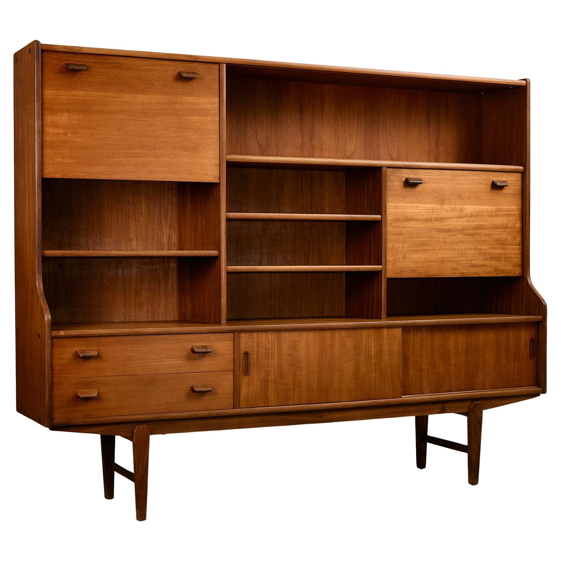 Tablero alto de teca de mediados de siglo con patas esculpidas, almacenaje y estante de cristal, años 60 en venta