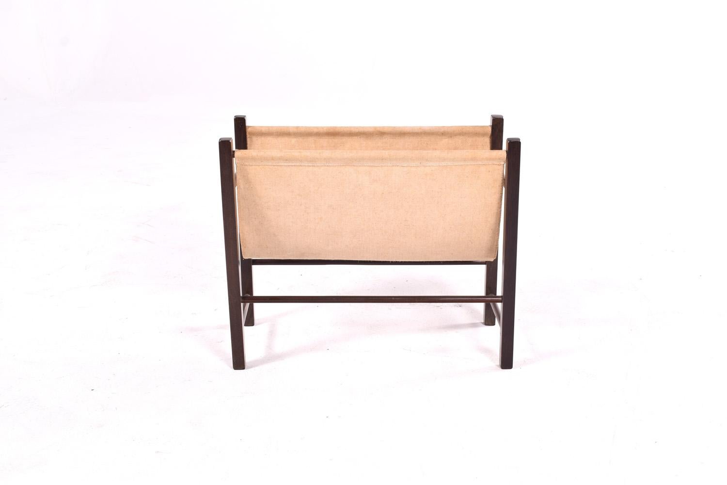 
This is a mid-century modern magazine rack, featuring a minimalist design that complements its functional purpose. The frame is made of teak, a high-quality hardwood known for its durability and beautiful grain, giving the piece a timeless appeal.