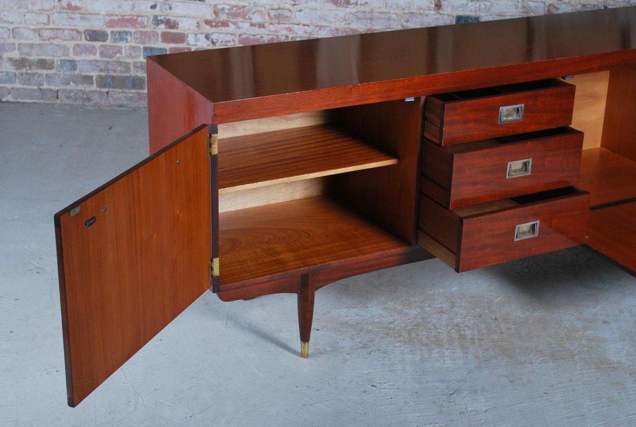 Mid century teak and mahogany long sideboard with brass handles by Greaves&Thomas, stamped 1966. 3 drawers, 2 cabinets and a drinks cabinet. Very good restored condition.

Dimension: W 220cm x H 76cm x D 45cm.