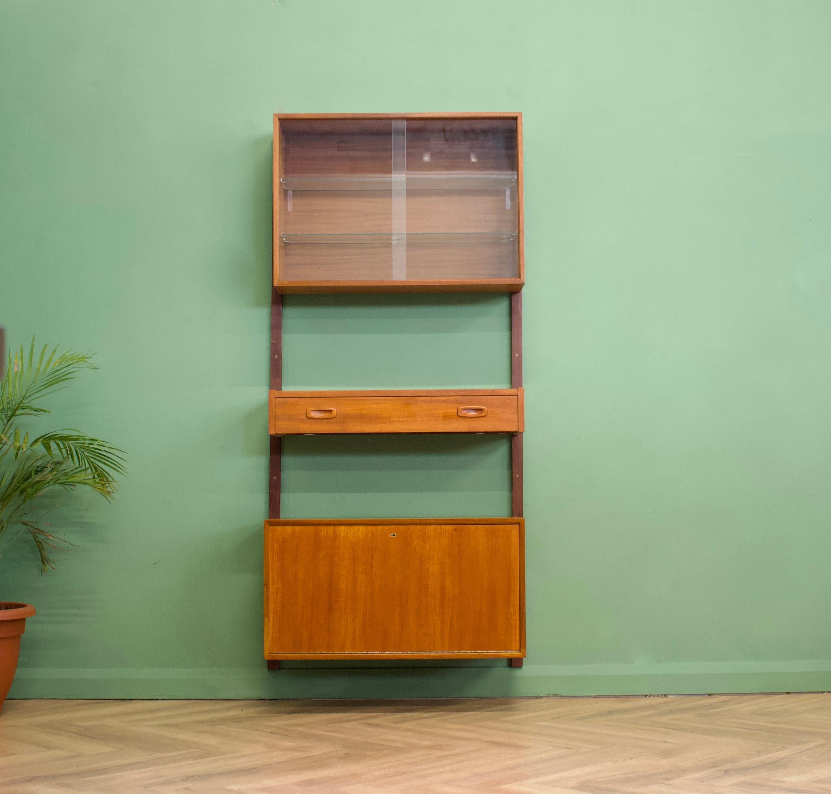Mid-Century Modern teak shelving unit or wall unit
Attributed to Prebend Sørensen

Featuring a sliding glass door unit, a drawer unit and a pull down cabinet - this piece is modular, the individual pieces can be moved to any height or position.