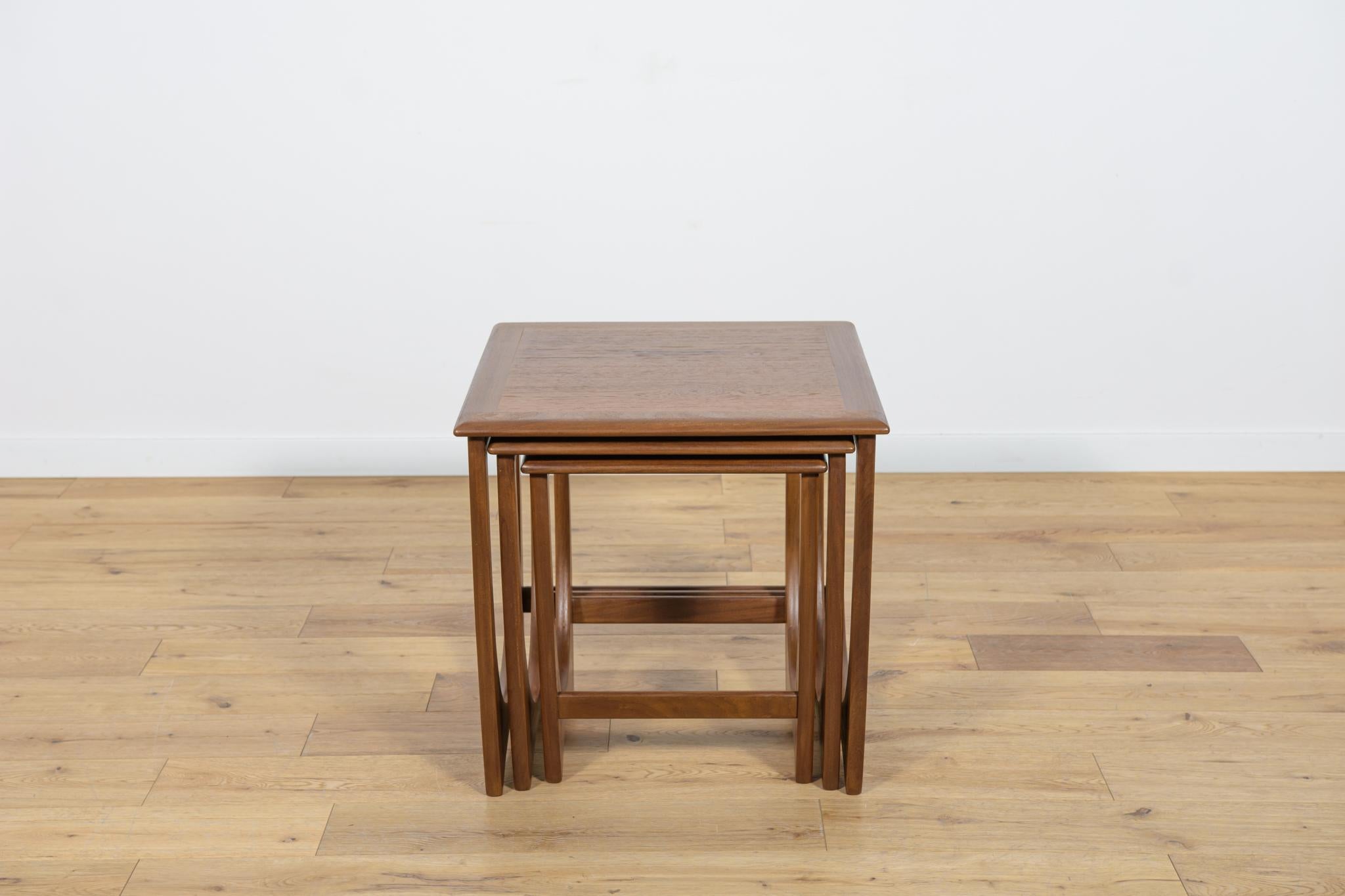 This set of three pull out tables was designed by Victor Wilkins for british manufatured G-Plan. The tables have reinforced profiled edges. Completely restored. The teak elements have been cleaned from the old surface and painted oak stain and