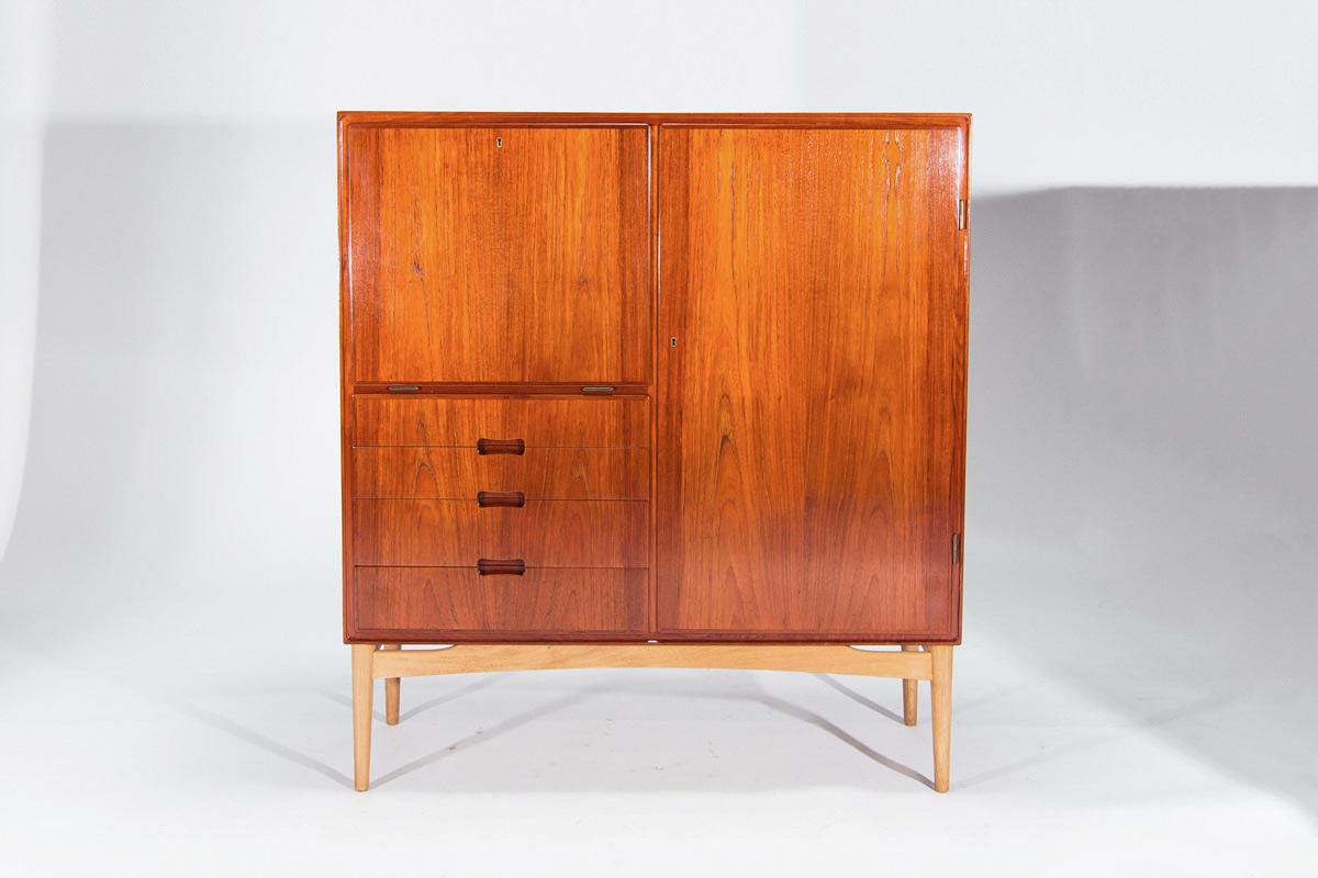 A fine Danish teak cabinet made in the 1950’s. A lovely mid century design the teak has a beautiful natural colour and patina created over years of use, complemented nicely by the oak base. A drop down door with 2 pull out drawers and shelve above 3