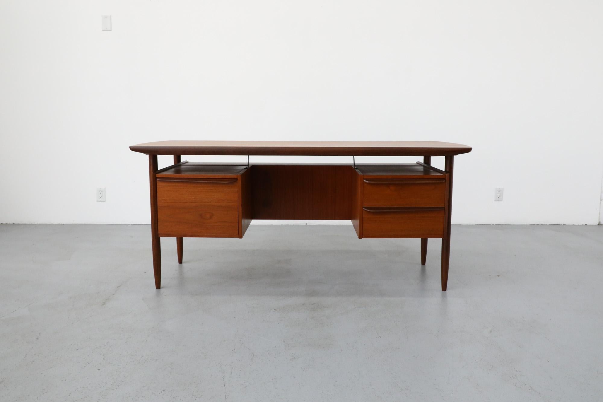 Gorgeous Dutch Mid-Century teak two-drawer desk with cabinet and privacy screen. This piece was the result of a unique collaborative effort between the Tijsseling company that designed it and the Hulmefa factory that manufactured it as part of their