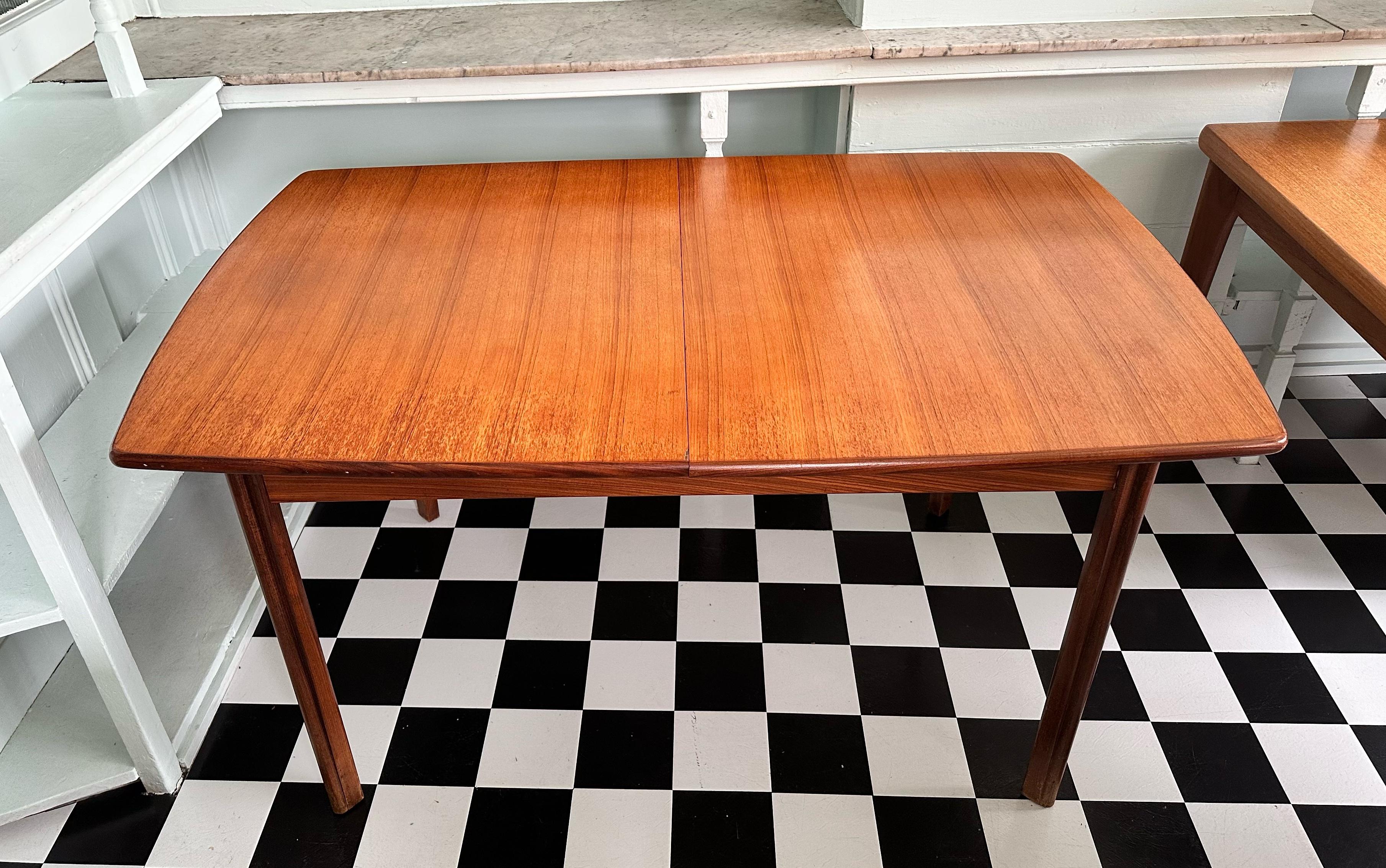 Beautiful mid-century modern teak rectangular extendable dining table. Having one butterfly extension (which is kept underneath the main two leaves when not in use), this table is very versatile. It is comprised of very stylish legs and an amazing