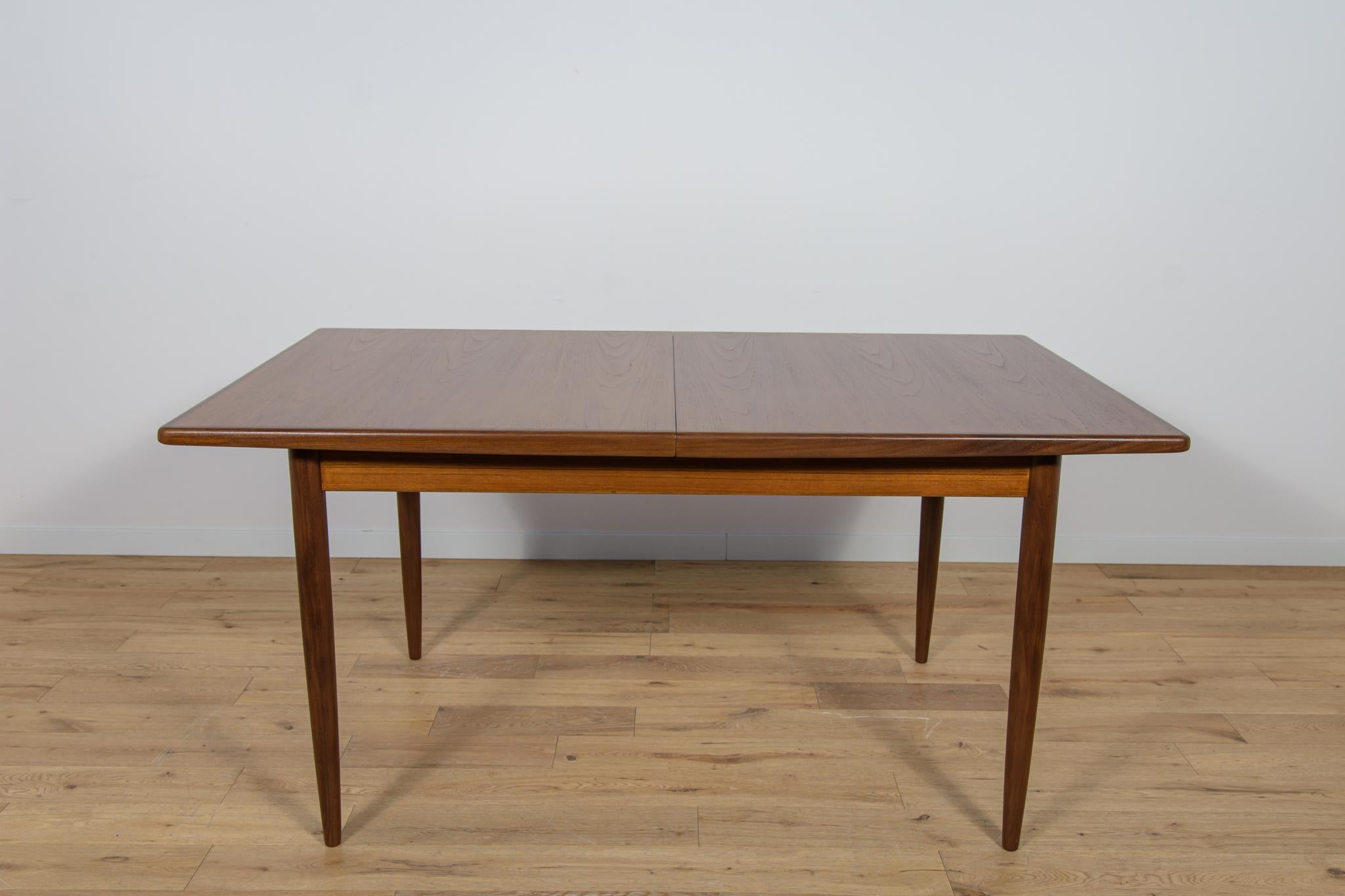 This rectangular  extendable dining table was produced by G-Plan in the 1960s. The table has profiled reinforced edges of the top. Teak elements cleaned old coating and painted oak stain and finished with strong semi matt lacquer. The table has a