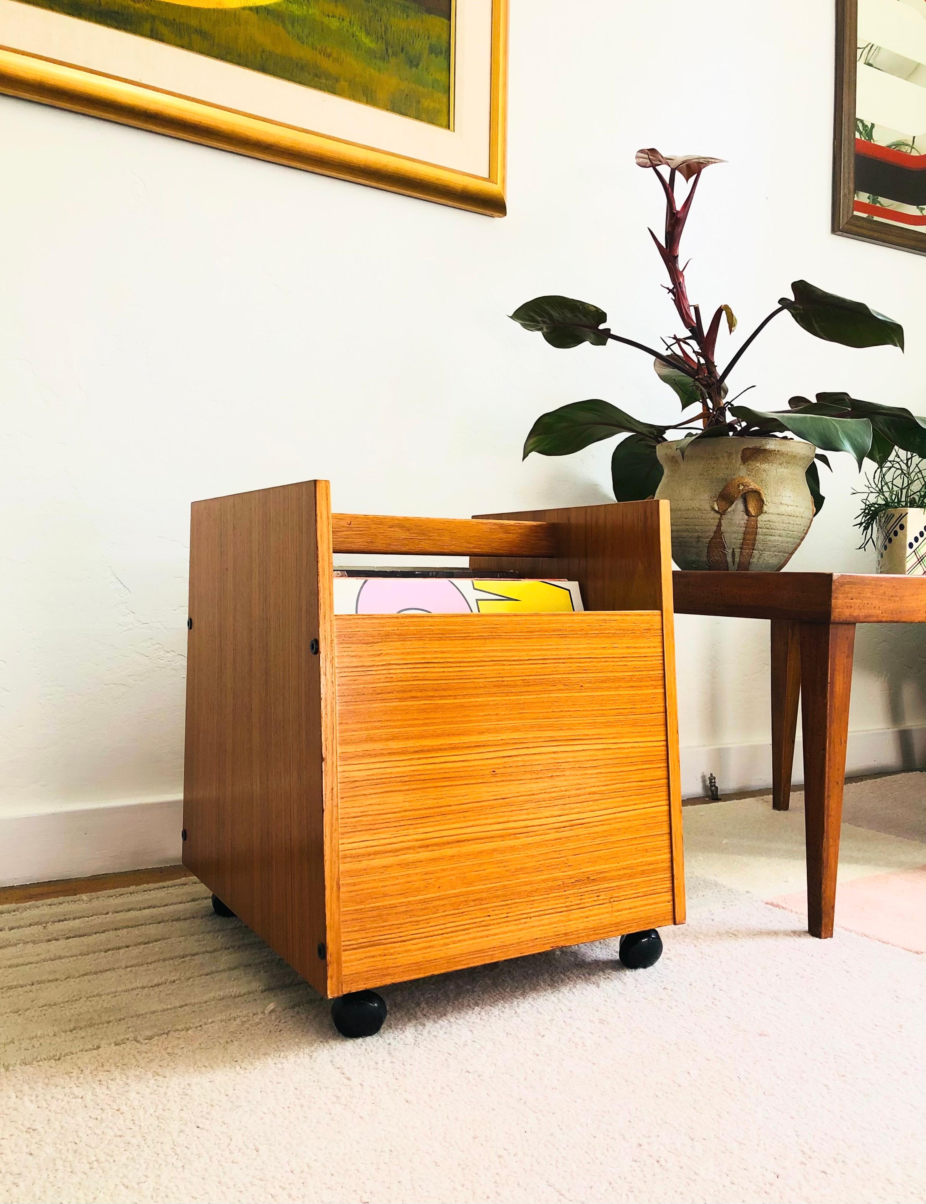A mid century teak record holder designed by Rolf Hesland for Bruksbo of Norway. Features 3 divided compartments for storing records or magazines and rolls smoothly on 4 casters. The original label is on the base.