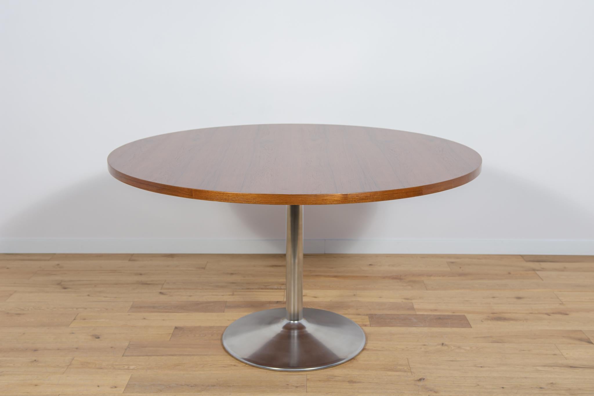 The table was produced in Denmark in the 1970s. Table top made of teak veneer. The furniture is after a comprehensive carpentry renovation, cleaned of the old coating, finished with high-quality Danish Oil. The table base is made of aluminum has