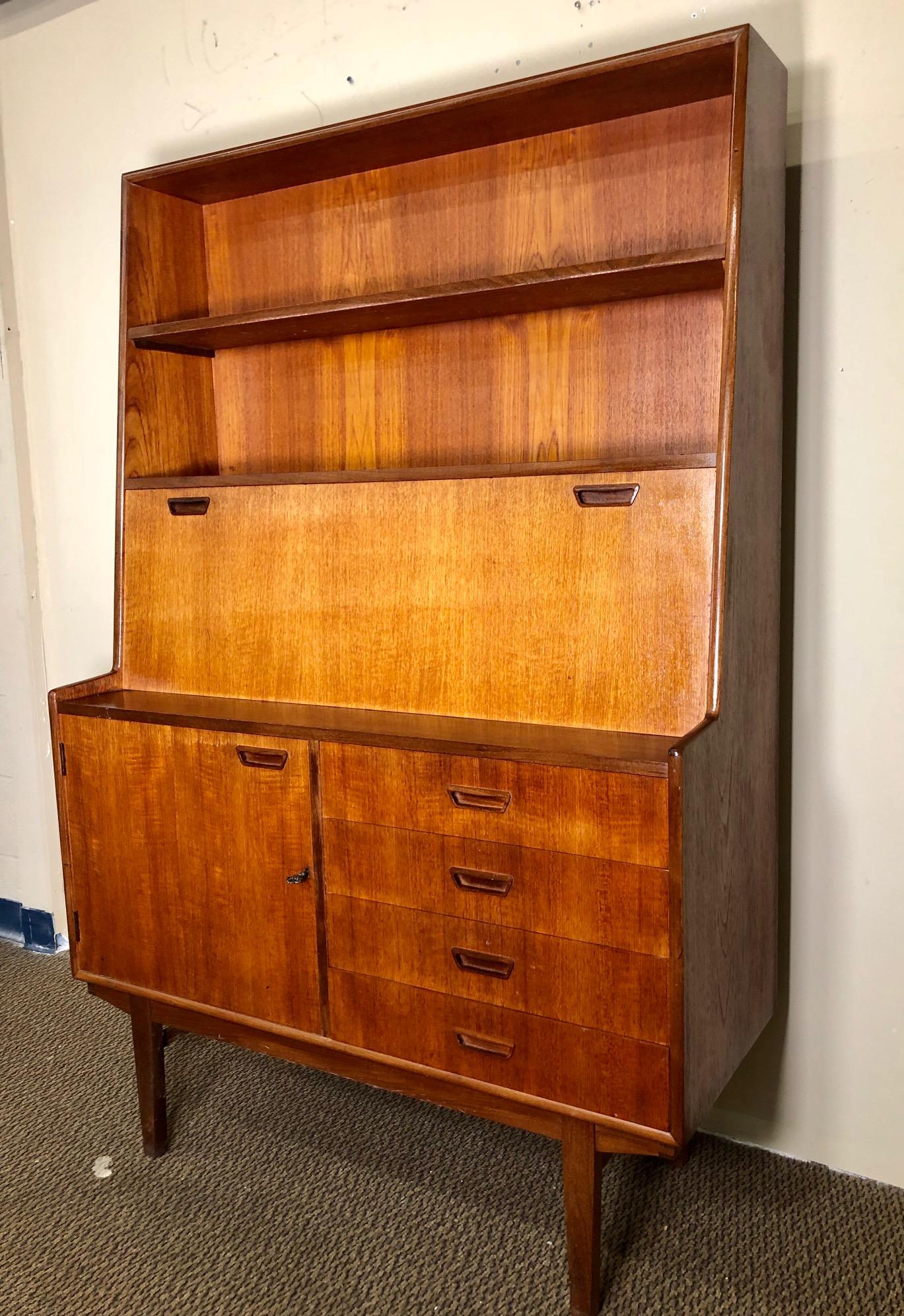 This is a beautiful teak secretary with 4 drawers and a cabinet door with key.
Made by Turnidge of London. Original label in the top drawer.
Condition:
Very good condition over all. Some stains and paper residue in side the drawers. Some light